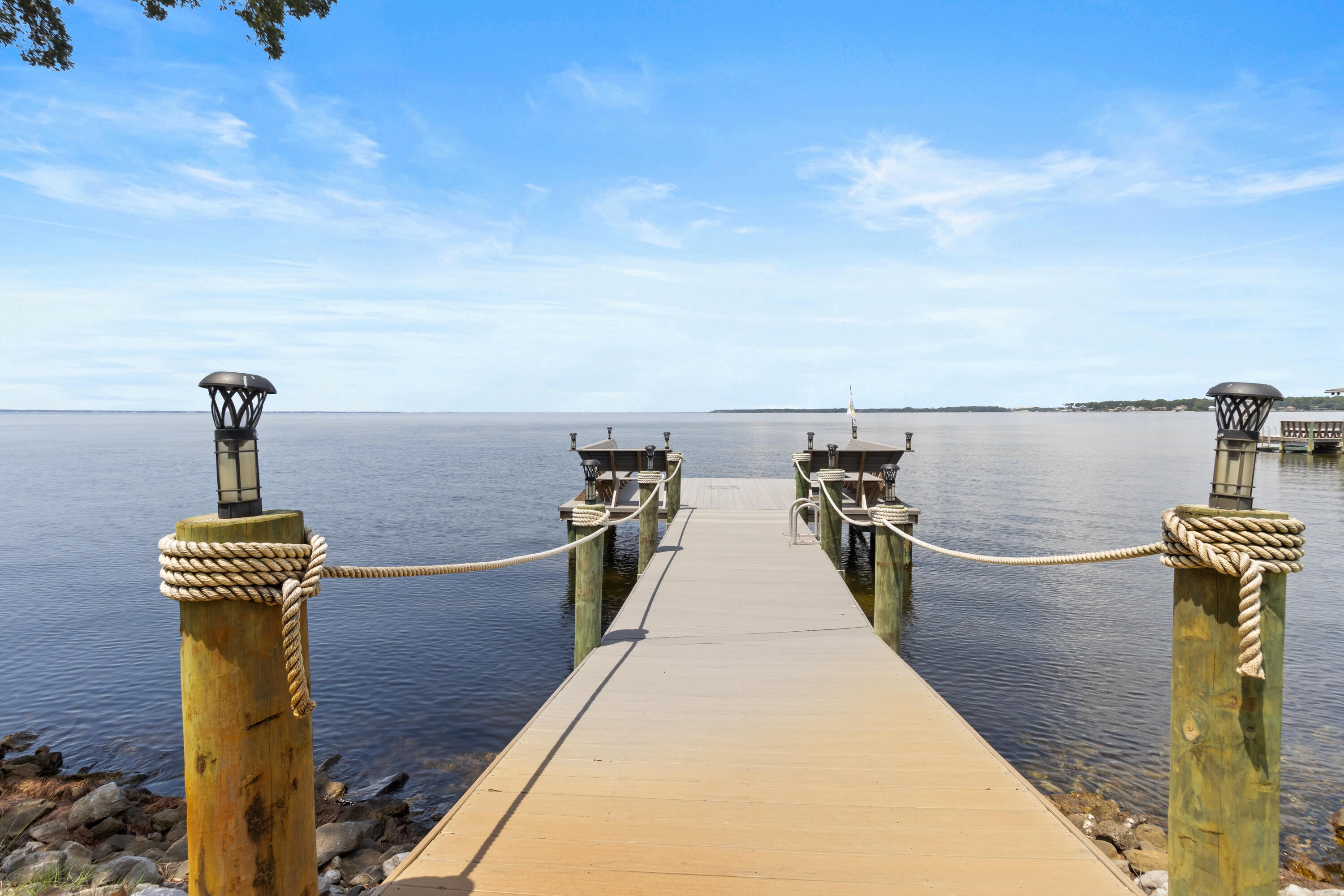 Offered exclusively for the first time, 923 Lido Circle presents a rare opportunity to own a masterfully designed European-inspired bayfront estate in the coveted Bluewater Bay community. Set along 100 feet of private Choctawhatchee Bay waterfront, this extraordinary residence offers nearly 7,000 square feet of living space and 8,710 total square feet, with beautiful water views and an exceptional setting for both everyday living and entertaining. Built by Maurice Sweet of Tier One Custom Homes, the residence reflects an uncompromising commitment to craftsmanship, quality, and detail, enhanced by meticulous German engineering. European-inspired design is woven throughout, from a historic scroll detailing the home's story and preserved beneath a glass-tiled entryway to custom Murano glass lighting throughout, imported finishes, and distinctive architectural elements. Designed with entertaining in mind, the expansive interiors provide an effortless backdrop for gatherings large and small, while the waterfront setting brings the beauty of Choctawhatchee Bay into nearly every experience. Thoughtfully appointed spaces, generous scale and timeless materials create a home that feels equally suited to elegant entertaining and relaxed coastal living. Private, sophisticated and unlike anything else currently offered in Bluewater Bay, 923 Lido Circle is an exceptional waterfront estate where craftsmanship, architecture and setting come together in a truly remarkable way. Each of the seven generously sized bedrooms features an ensuite, providing comfort and privacy for family and guests. A bay front office with a private bath serves as a tranquil work-from-home space with panoramic water views. The chef's kitchen is equipped with premium Miele appliances, including a steamer, wine refrigerator, ice maker, and a refrigerated walk-in pantry, perfect for both entertaining and everyday luxury. Large, open-concept living areas flow seamlessly, creating a layout ideal for gatherings, while still offering intimate retreats throughout the home. Outdoors, a fully enclosed saltwater pool and spa are surrounded by covered patios and balconies, with a summer kitchen complete with food prep and cooking areas. Whether relaxing by the pool or entertaining guests, the outdoor living spaces provide year-round enjoyment with sweeping views of the bay. The property's private party deck extends over the bay, providing a front-row seat to daily dolphin sightings, vibrant sunsets, and colorful rainbows. It's also equipped for boat dockage, offering convenient access to boating and water sports. Additional features include a guest house under beam, oversized walk-in closets, bidets in most bathrooms, solar panels for energy efficiency, and electronically controlled storm shutters for added security and peace of mind. Located in a quiet, upscale enclave of Bluewater Bay, this home is just minutes from the marina, Freedom Boat Club, sailing, water sports, LJ Schooners waterfront restaurant, and a host of recreational amenities, including golf, tennis, pickle ball, community pools, and walking trails. Destin's famed white-sand beachesincluding Crystal Beachare only a 10-minute drive away. The area also offers proximity to top-rated schools, shopping, dining, parks, hospitals, and all the conveniences of the Emerald Coast lifestyle. For the discerning buyer seeking a serene retreat that doesn't compromise on luxury, access, or amenities, this home represents an unparalleled coastal living experience.