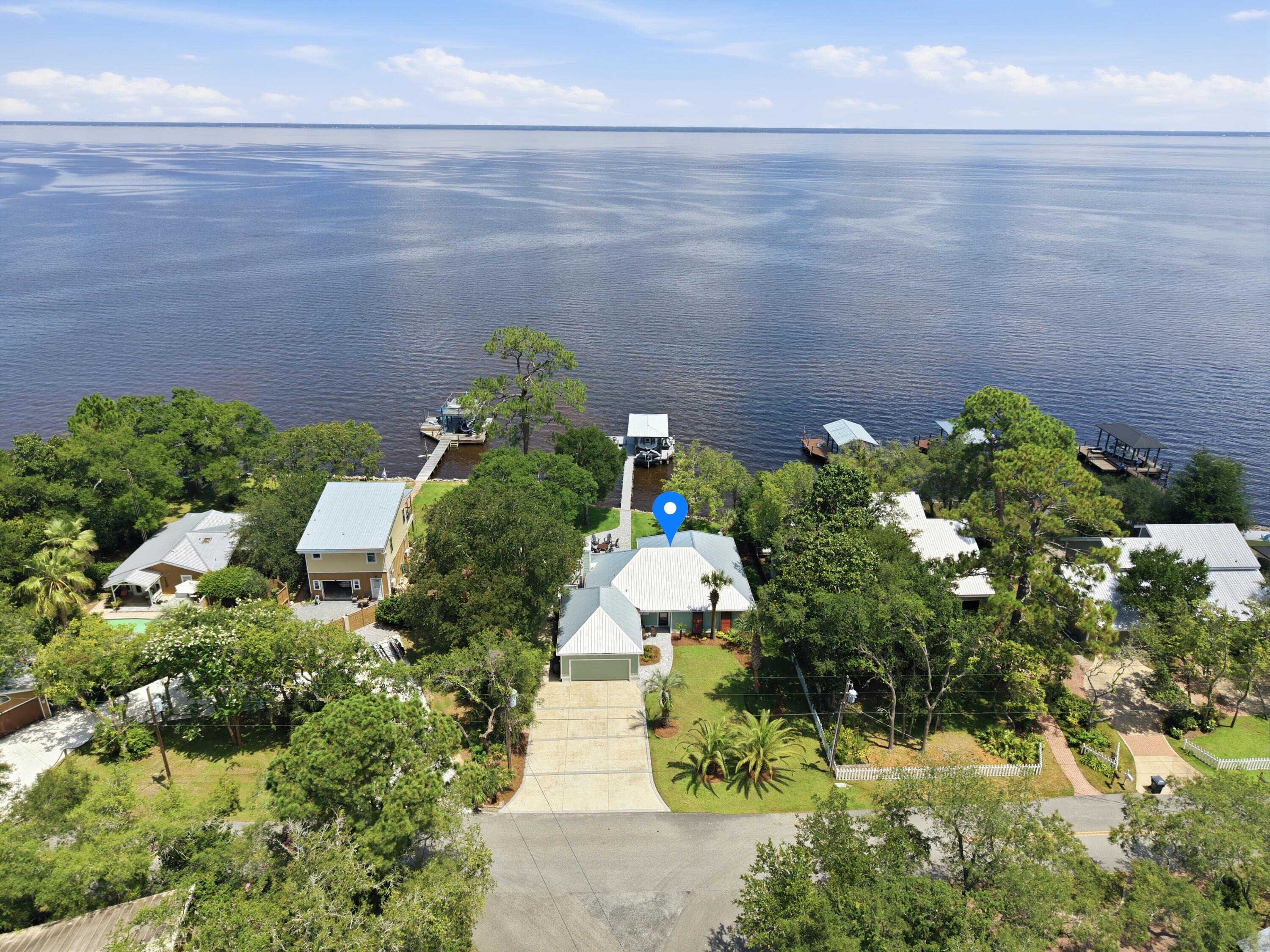 Beautifully remodeled coastal home featuring a private dock, boat lift, and exceptional views across the bay. Located on a quiet stretch of Santa Rosa Beach just minutes from Scenic 30A, 
Designed to capture the stunning bay views, the open floor plan features inviting living spaces with a fireplace and a beautifully appointed kitchen with an island. Updated windows and doors fill the home with natural light while creating a seamless connection to the water and outdoor living areas. Carefully designed landscaping provides privacy while maximizing the expansive bay views. 
The primary suite offers a private retreat with a dedicated office, walk-in closet, and beautifully finished bath.
Outdoor living is where this property truly shines, featuring a wraparound deck, covered porch, outdoor shower, and fire pit overlooking the bay. 
The waterfront setup is exceptional, with a dock, walkway, and boat lift built on durable concrete pilings. The dock includes a beautiful boathouse, two Jet Ski lifts, a kayak and paddleboard launch platform, and a sunning deck / lounge area perfect for relaxing by the water.
The bay creates a peaceful natural setting where dolphins, nesting ospreys, and herons are frequent visitors, offering a rare connection to the beauty of the Emerald Coast.
Featuring a 2023 metal roof, updated windows and doors, and numerous quality upgrades throughout, this meticulously maintained bayfront home combines coastal elegance, thoughtful improvements, and an unmatched waterfront setting in one of Santa Rosa Beach's most desirable locations.