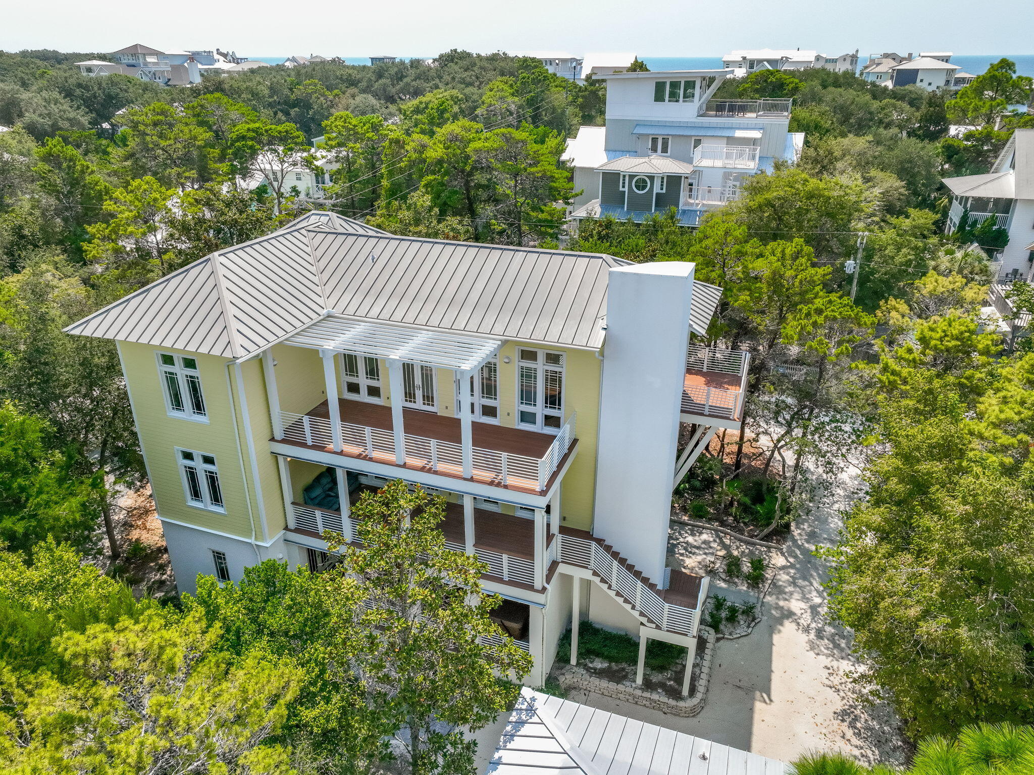 Nestled under Old Seagrove's iconic tree canopy and just two blocks from both the beach and Seaside, this three-story contemporary home (4645 sq-ft) blends architectural pedigree with coastal charm. Designed by acclaimed Tom Christ of Christ & Associates, a Seaside Prize-winning architect whose visionary work has shaped much of 30A's distinctive style. The main home delivers light-infused living with expansive covered porches and soaring floor-to-ceiling windows. On the first floor, you'll find a guest suite with private bath, walk-through laundry, and a massive unfinished flex space -- perfect for a future primary suite, media room, or game lounge.On the second floor, the open-concept living and dining area opens onto porches on both sides creating an ideal indoor-outdoor flow. A guest suite with a walk-in shower rounds out this level. The third floor is a private retreat: the primary suite stuns with wall-to-wall windows, a private balcony, dual closets, and a spa-worthy bath with double vanity, garden tub, and walk-in shower. Plus, there's a second guest room with pre-plumbing area ready for an ensuite bath.
 Carriage House (781 sq-ft) 2 bedrooms, 1 bath and a full kitchen, perched above a 3-car garage complete  and 11 x11 air conditioned space. Ideal for multi-generational living, vacation guests, or rental opportunities.Designed by a local design legend, this Seagrove gem offers the best of both worlds smart, stylish architecture and unbeatable proximity to the Gulf and Seaside's vibrant hub.***Buyer is responsible for personally verifying details about this Any information contained in this listing is believed to be accurate but not guaranteed.***