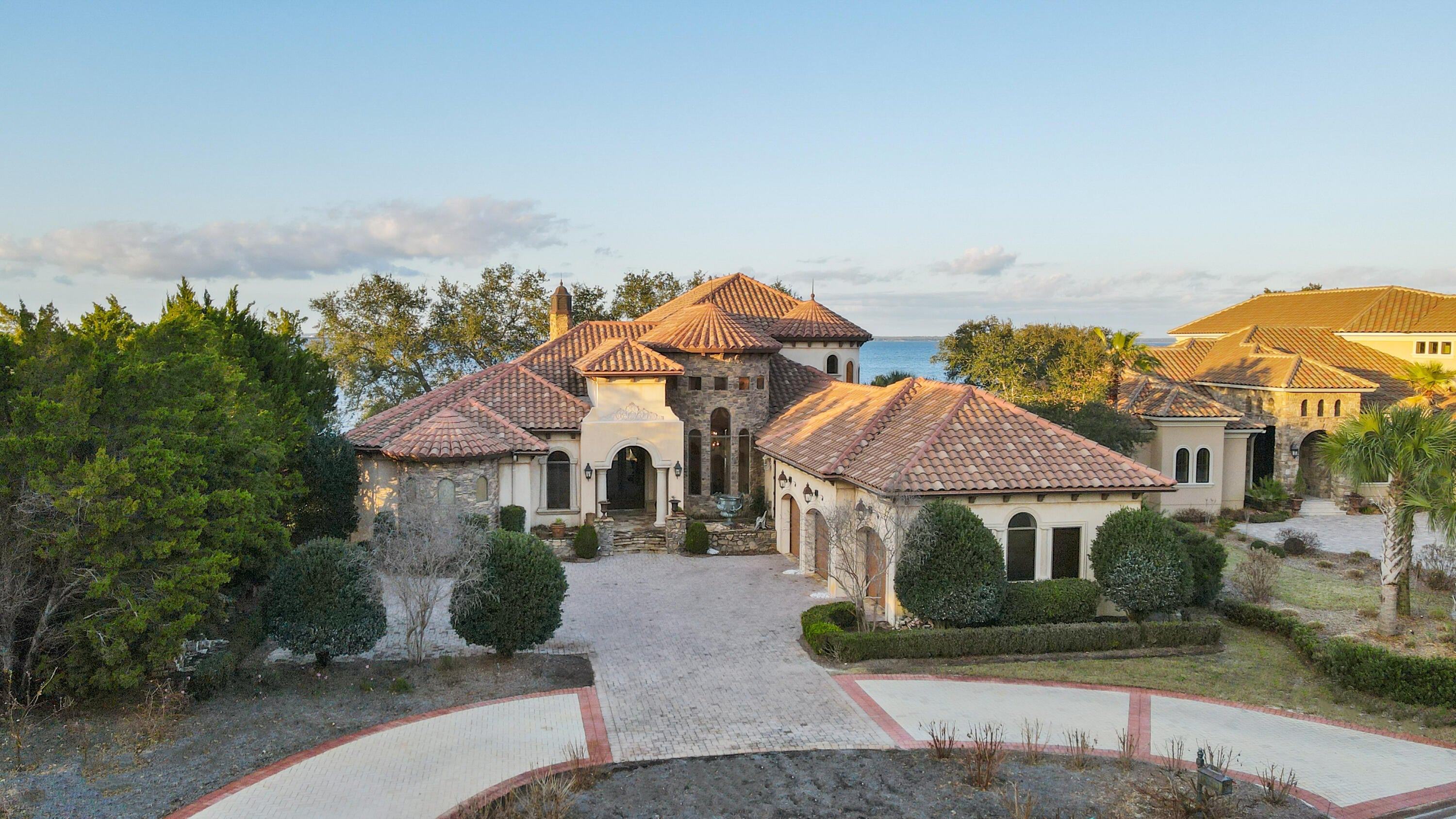 Few properties in Destin can claim what Sand Castle Patron delivers: lake views from the front, sweeping panoramic bay views from the back, and some of the most breathtaking sunsets on the Emerald Coast framed from the privacy of your own home. Featured on the Discovery Channel's American Dream Home, this ICF-constructed estate in Regatta Bay was built to impress and engineered to endure. Inside, beamed ceilings, hardwood and marble floors, crown molding, and a Swarovski crystal chandelier anchoring the great room create a residence that feels both grand and genuinely livable. Outside, nearly 1,200 square feet of screened lanai open to a heated saltwater pool, spa, summer kitchen, and outdoor fireplace--all set against 118 feet of coveted bay shoreline. A private home gym, dedicated office, and split bedroom configuration round out a home where every detail supports the way its next owners will want to live. Beach access by golf cart. Bay living every day.