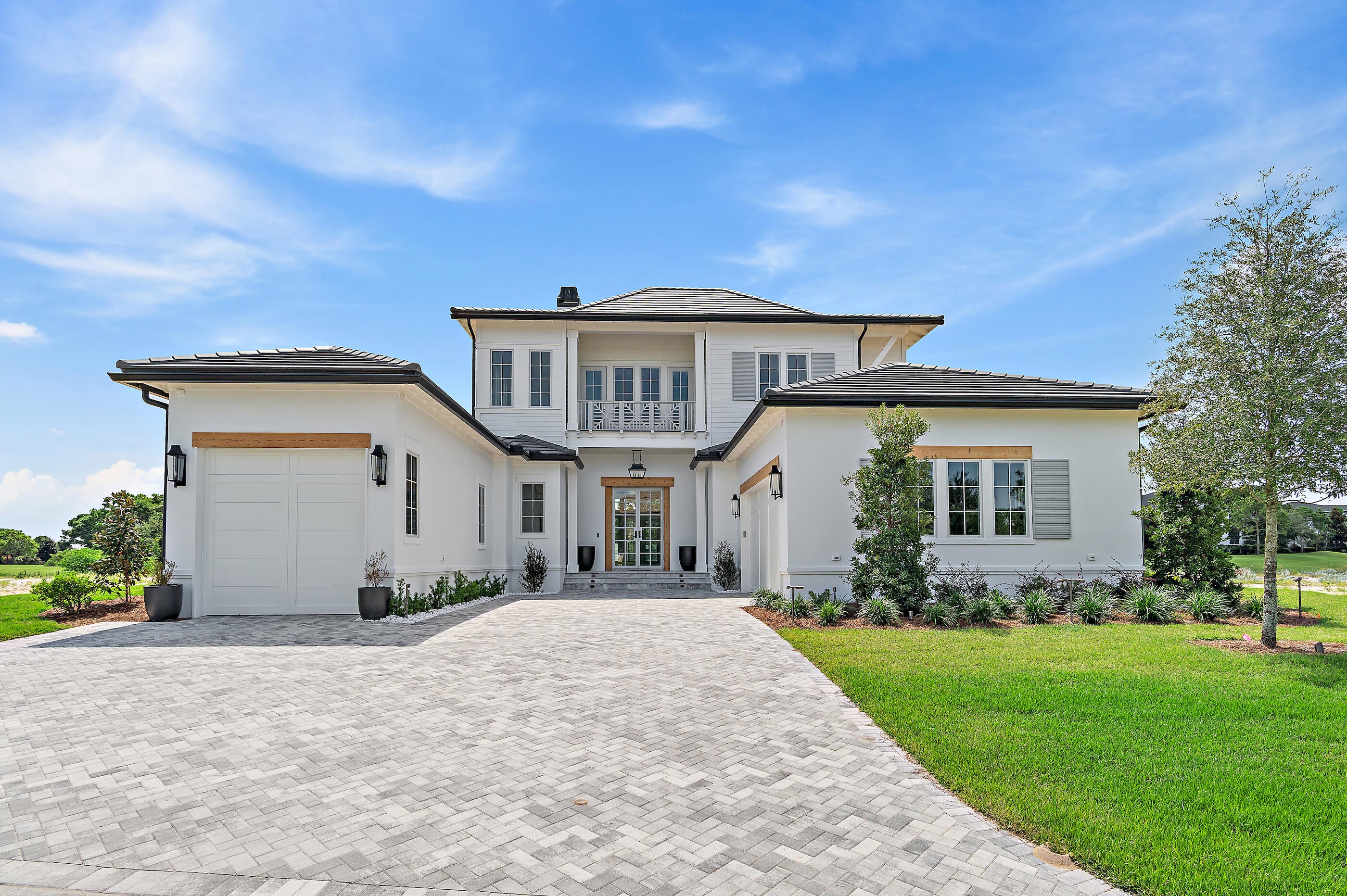 August 2026! Located less than a mile from the beach, this spectacular new construction home showcases exceptional craftsmanship, sophisticated design and modern coastal luxury. Tradewinds, Regatta Bay's newest community, features just 54 homesites inspired by elegant West Indies and Dutch-Caribbean architecture. Perfectly positioned on a premium lake and golf course lot, this stunning home offers over 4,000 square feet of heated and cooled living space, featuring five bedrooms, five full baths and two half baths. Designed to embrace seamless indoor-outdoor living, the residence surrounds a private backyard retreat complete with an Alys Beach-inspired pool, hot tub, outdoor fireplace and summer kitchen--creating the ultimate setting for entertaining and relaxation. Inside, the open-concept floor plan is both elegant and inviting. The spacious living area is highlighted by a custom fireplace and flows effortlessly into the gourmet kitchen, which features quartzite countertops, an oversized island, premium appliances and an expansive butler's pantry. The first-floor primary suite serves as a private sanctuary with tranquil lake and golf course views and direct access to the outdoor living spaces. Its luxurious spa-inspired bath includes dual vanities, designer lighting, a custom-tiled walk-in shower, a freestanding soaking tub and a generously sized custom walk-in closet. The main level also includes a powder bath for guests, wet bar and a guest suite with an ensuite bath. Upstairs, a spacious bonus room with an additional wet bar provides the perfect gathering space, while three additional guest suites each feature private baths. A versatile flex room offers additional storage or multipurpose space and an expansive covered balcony provides the ideal place to enjoy evening sunsets and coastal breezes. Built by Legendary Home Builders, this exceptional residence incorporates premium materials and luxury finishes throughout, including impact-rated windows and doors, insulated impact-rated garage doors, interior wall insulation for energy efficiency, soundproofing insulation between floors, stainless steel hardware, custom wood closet shelving, Kohler plumbing fixtures, custom solid wood cabinetry with soft-close features, surround sound, smart home technology, LED lighting, and much more. Combining timeless architecture, thoughtful design, and an unparalleled location just moments from the beach, this extraordinary home offers the very best of luxury coastal living.