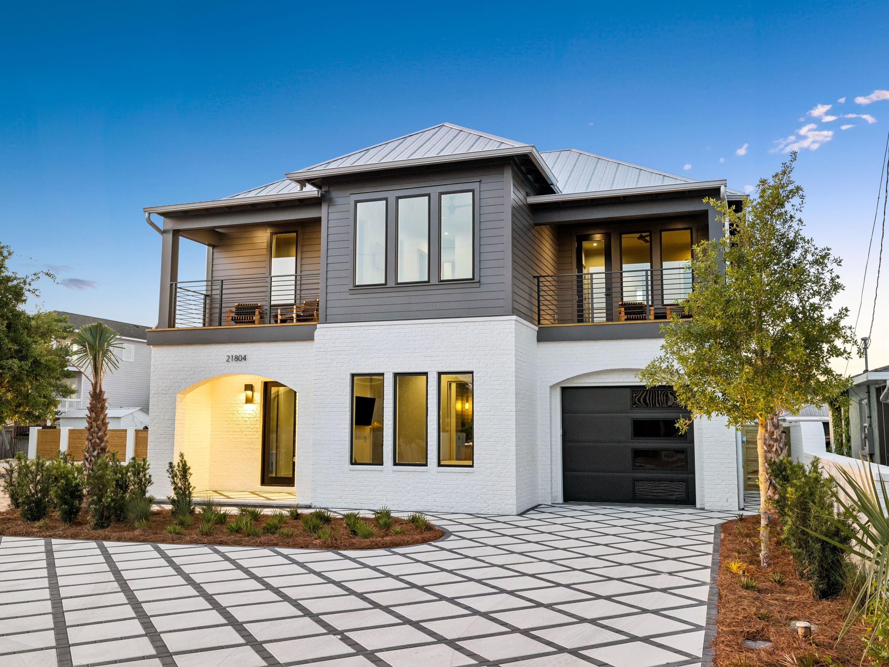 Welcome to 21804 Sunset Avenue, where modern coastal design meets refined luxury just 0.3 miles from the sugar-white beaches of Panama City Beach.

This professionally designed new construction residence offers 2,865 square feet of heated and cooled living space across a two-story, five-bedroom, four-and-a-half-bathroom layout that balances elevated design with everyday livability. Clean architectural lines, a striking façade, and a generous driveway with parking for six vehicles, along with a one-car garage, create a memorable arrival. Inside, a light-filled open-concept floor plan is enhanced by 10-foot ceilings, expansive windows, and thoughtfully curated finishes throughout. The chef's kitchen serves as a true centerpiece, featuring premium quartz countertops, custom cabinetry, and a full appliance suite including built-in refrigerator, dishwasher, additional wall oven w/ microwave, and natural gas range. Additional interior highlights include luxury vinyl plank flooring, eight-foot solid wood interior doors, custom closet systems, micro-cement accents, and low-profile mud-in HVAC grills for a seamless, elevated aesthetic.

Constructed with both efficiency and durability in mind, the home incorporates 2x6 framing, R-19 insulation, a spray-foamed roof deck and midfloor, dehumidifer w/ fresh air intakes, and impact-rated windows, doors, and garage door.

The private outdoor setting is designed for a sophisticated coastal lifestyle, complete with a heated saltwater pool with waterfall feature and auto-fill system, complemented by low-maintenance landscaping. A covered summer kitchen with a built-in natural gas grill, along with integrated outdoor audio, CAT6 wiring, whole-home WiFi boosters, and smart thermostats, supports effortless indoor-outdoor living. An outdoor shower and brick privacy wall complete the experience.

Thoughtfully designed and meticulously constructed, this residence offers a compelling combination of modern luxury, efficiency, and a highly desirable coastal setting.