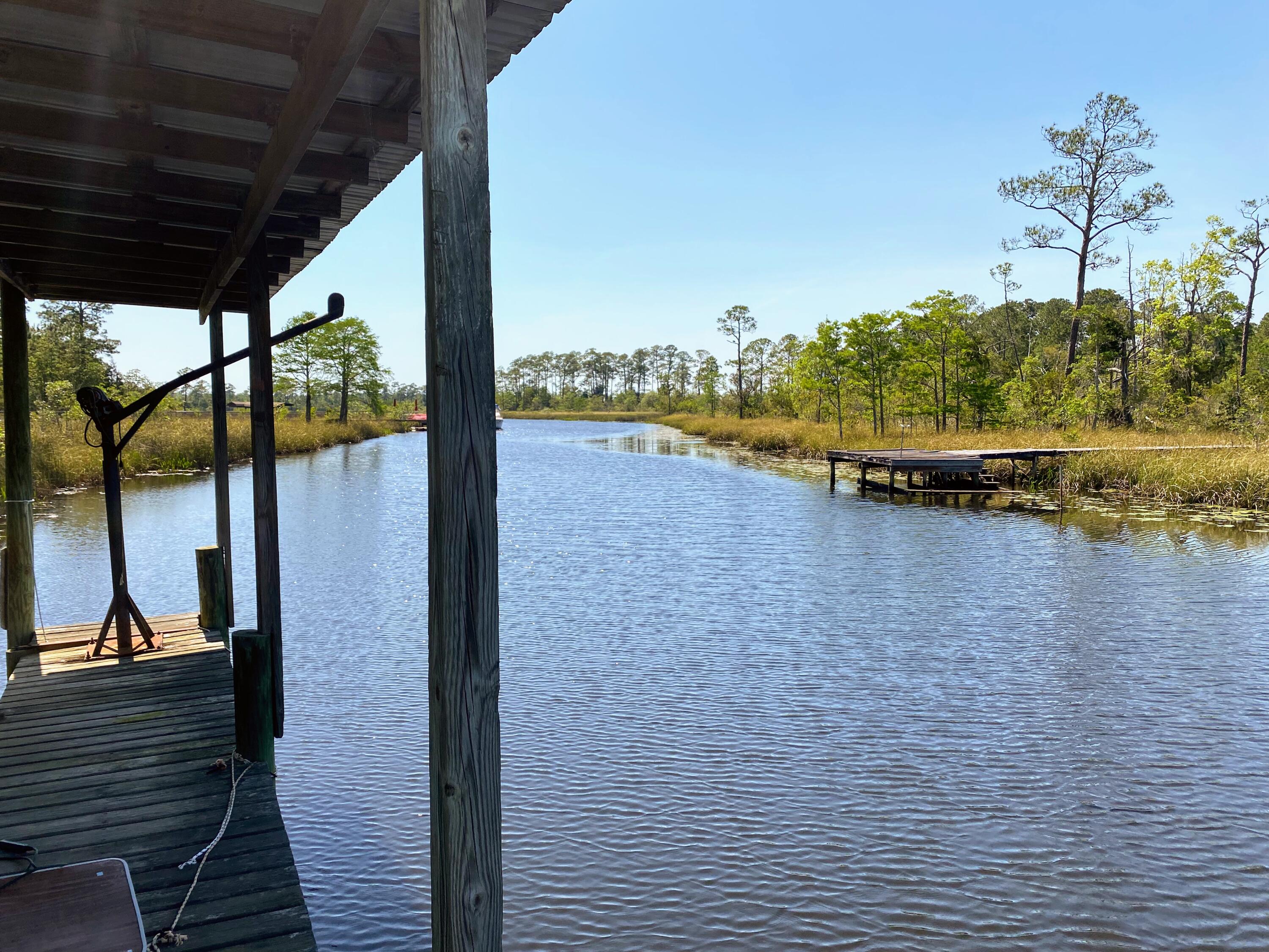 WATERFRONT. A rare opportunity to affordably own a large waterfront parcel (parcel split) with dedicated shared ownership and access to an existing private dock, offering immediate enjoyment of the waterfront lifestyle while you plan and build your dream home.

From your dock, explore Escambia Bay, the Blackwater River, the Gulf of Mexico, and even cruise by boat into historic downtown Milton. This peaceful waterfront setting offers the best of both worlds--an uncrowded, Old Florida atmosphere surrounded by nature, yet with exceptional convenience. Interstate 10 is less than five minutes away, providing an easy commute to Pensacola, while the property's location on the east side of Escambia Bay allows quick access to Navarre Beach without crossing the toll bridge.

The generous homesite features ample upland area for construction while the shoreline remains protected as a natural Florida marsh, ensuring your waterfront views and the property's unspoiled character are preserved for years to come. Unlike many waterfront conservation properties, this parcel includes shared ownership and use of an existing private dock, allowing you to enjoy boating, fishing, kayaking, and waterfront sunsets from day one.

Whether you're envisioning a private coastal estate, a weekend retreat, or your forever home, this property offers an exceptional combination of privacy, natural beauty, boating access, and convenience.

Survey, wetlands delineation, and dock access documentation are available