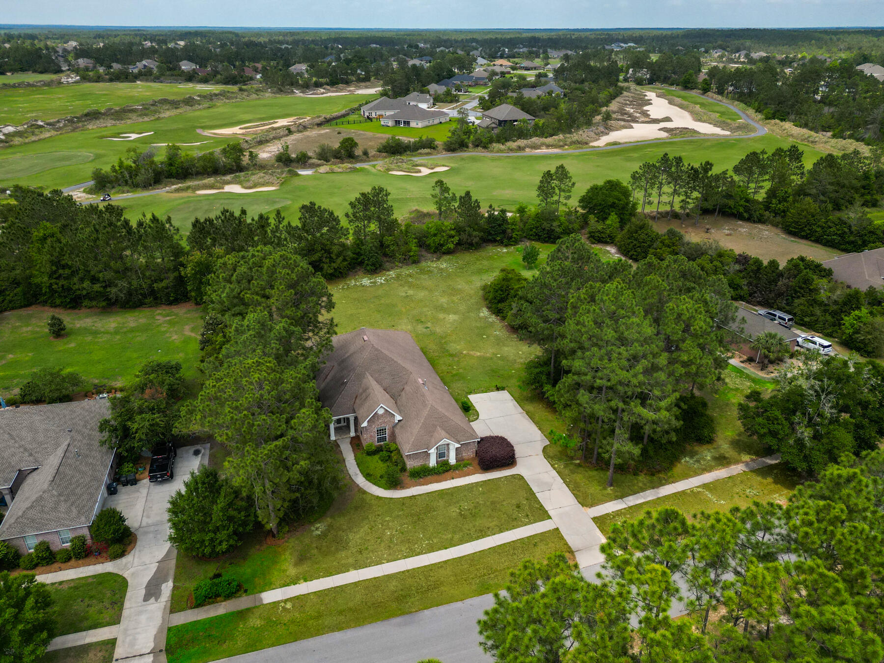 This 3-bedroom, 2-bathroom home is located on the 18th hole of the Windswept Estates gated, golf course community, sitting on a private .92-acre lot.. This single-story home is move-in ready with a new roof 2025, newer AC, water heater, LVP flooring and tile throughout, and new paint throughout. The spacious kitchen is the heart of the home, while the living room features 14-foot ceilings, a fireplace, and flows into a formal dining room, ideal for family gatherings. The primary bedroom offers a large in-suite bath and oversized walk-in closet. Both the living room and primary bedroom have direct access to a covered patio and large, private backyard perfect for outdoor entertaining.