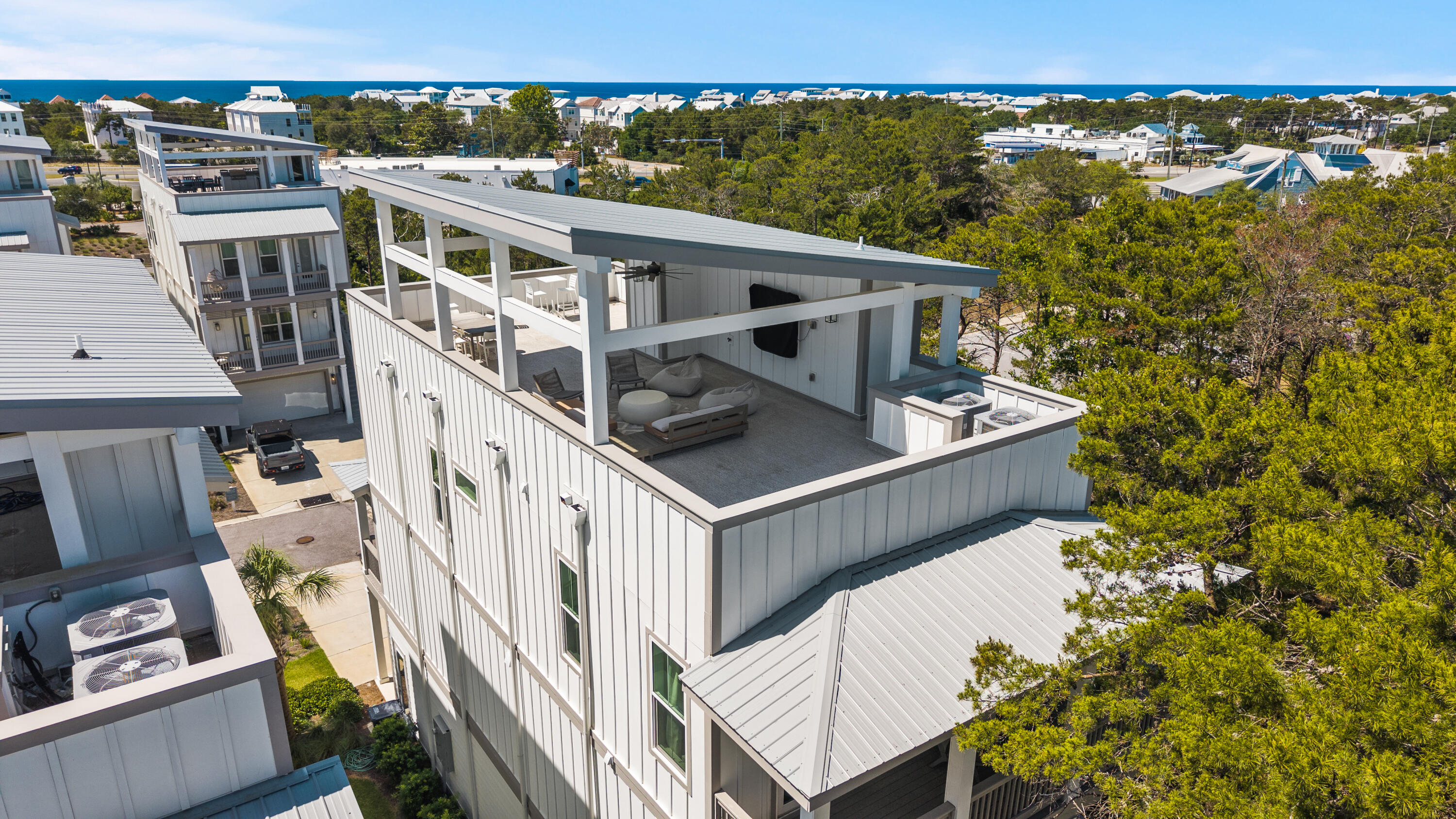 Tucked within the Twin Palms enclave of Inlet Beach, 34 Majestic Palm offers Gulf views and a refined take on coastal living with a layout designed to balance comfort, flexibility, and long term value.

Spanning three stories and topped with a full roof deck, this Brock Built residence features four bedrooms and four and a half baths, along with a dedicated office that allows the home to adapt to both extended stays and remote work. The design leans into functionality without sacrificing scale, creating a property that works just as well as a private retreat as it does in a rental capacity.

The main living level is centered around connection. An open kitchen, dining, and living space is filled with natural light, framed by clean finishes and a coastal palette that feels relaxed yet intentional. The flow is easy, designed for gathering without feeling overdone, whether hosting guests or settling into a quieter pace.

Each bedroom is positioned with privacy in mind. A first floor suite offers convenience and separation, while three additional suites on the third level create a sense of retreat for family and guests. Every space is paired with its own bath, reinforcing comfort across the home. The third floor also offers Gulf views, always beckoning you back to the beach.

At the top level, the experience shifts. The rooftop terrace stretches wide, offering Gulf views that elevate the entire property. It is an open, expansive setting that captures both light and perspective, creating a natural extension of the home that feels equally suited for entertaining or unwinding at the end of the day.

Practicality is woven throughout. An oversized garage provides space for both vehicles and a golf cart, making it easy to navigate to 30A, the beach, and nearby dining and shopping without relying on a car. Ample storage space makes guest stays easy with plenty of storage still available for lockable owner access.

For those thinking beyond a single property, the opportunity becomes even more compelling. The same ownership is offering 28 W Queen Palm just one street over, creating a rare chance to secure two homes within the same neighborhood, a strategy that is increasingly difficult to replicate along 30A.

34 Majestic Palm delivers a strong combination of layout, location, and livability. In a part of Inlet Beach where access and usability continue to drive demand, it stands as a thoughtful option for both personal enjoyment and long term investment.