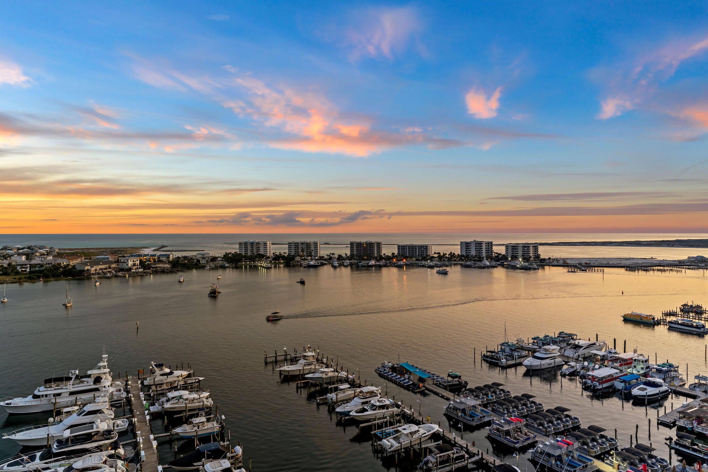 Welcome to Penthouse 1201 located in the iconic Destin Yacht Club, where sweeping views of the Destin Harbor to the Gulf create a stunning backdrop for refined coastal living. This rare corner residence features expansive windows and a spacious balcony that capture breathtaking views of the Destin Harbor and the Gulf of America. Perfect for the boating enthusiasts, this penthouse includes a deeded 55' deep-water boat slip. Destin Yacht Club is a private, secure gated community with world-class amenities, including a marina, resort-style pool, fitness center, and community room, ideally located in the heart of Destin. Your coded pedestrian gate gives you direct walking access to fine dining, shopping, and everything that Harborwalk Village and the Destin Harbor have to offer.