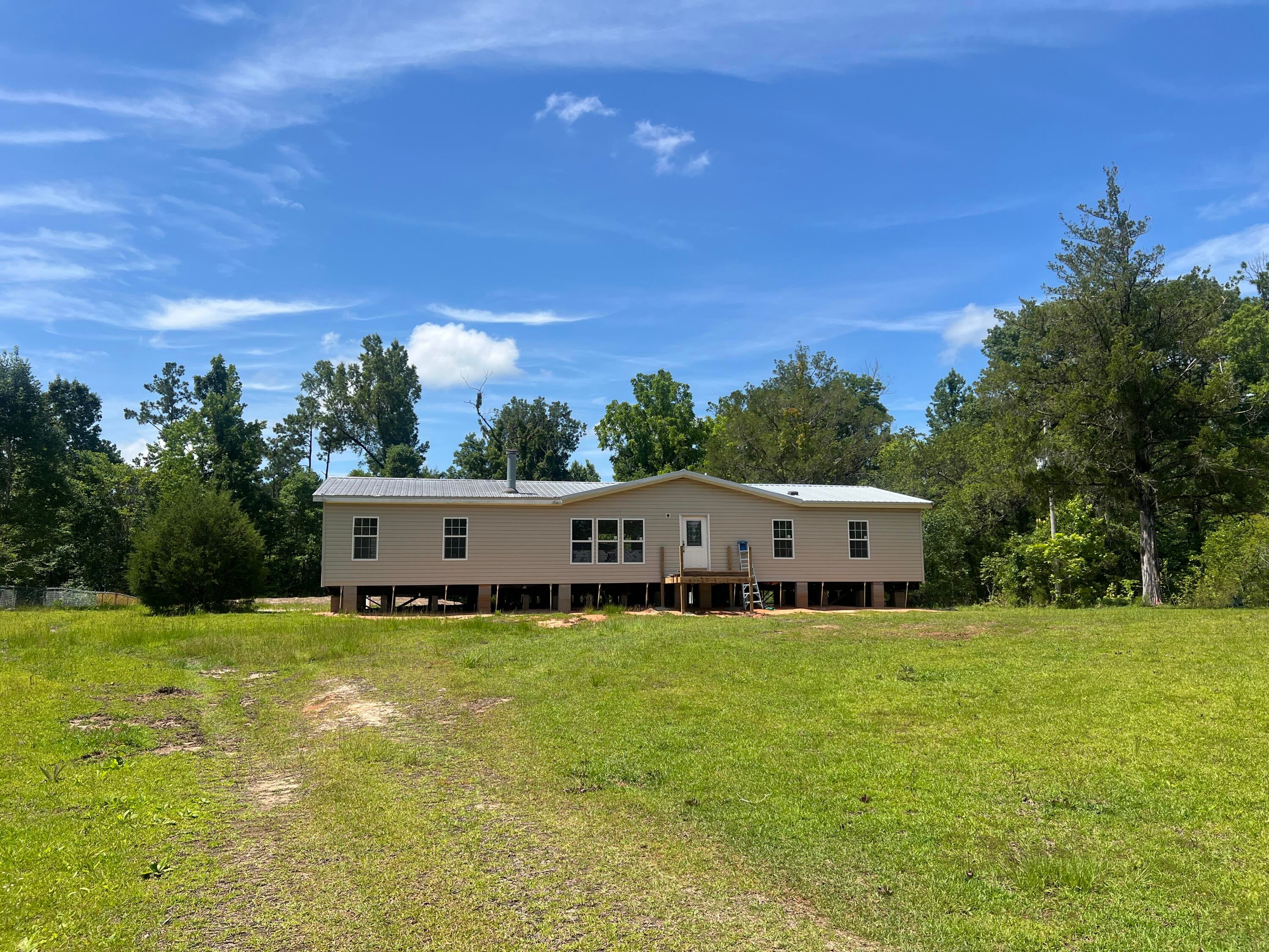 Don't miss out on this spacious, refreshed home on just over an acre in Marianna. You'll love the open floor plan, inviting fireplace, and split bedroom layout. All new: flooring, paint, AC, siding, skirting, shutters, septic, porch, and deck! New windows throughout most of the home.  5 miles to downtown Marianna. Just over an hour to the beautiful beaches of Panama City and Tallahassee.