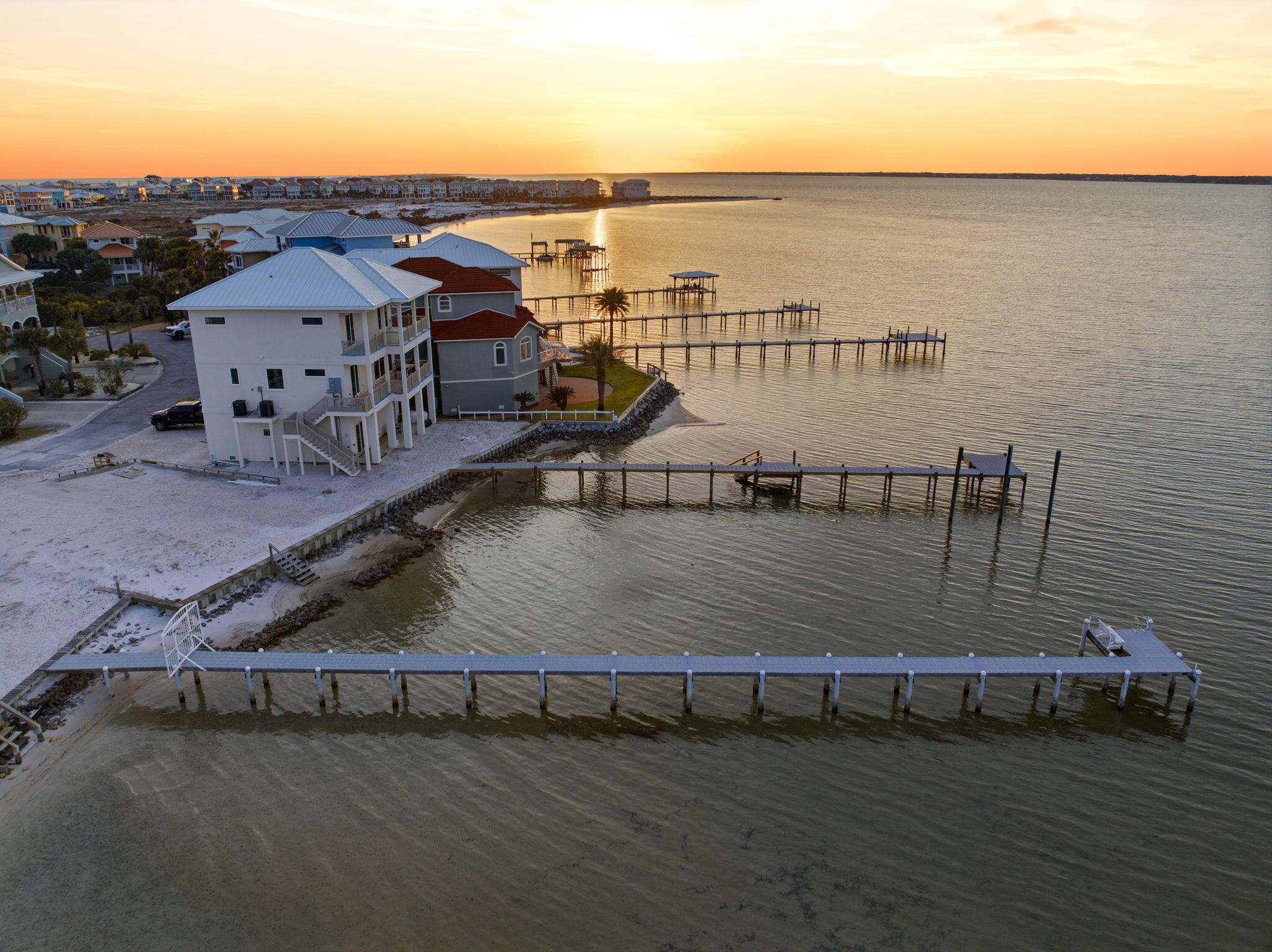 NOW COMES FULLY FURNISHED! Summer is here! MOVE IN READY! 

Welcome to Your Private Coastal Sanctuary in Caribbean Isle on Navarre Beach

From the moment you enter the exclusive, gated community of Caribbean Isle, you're transported into a true tropical paradise--complete with winding roads, vibrant coastal architecture, underground utilities, streetlights, and resort-style amenities including a community pool and tennis courts.

Perfectly positioned in one of the most desirable locations within the neighborhood, this custom-built, one-owner beach home offers the ultimate blend of privacy, convenience, and luxury. Just steps from your back door, you'll find direct access to the sugar-white sands and emerald waters of the beach. Enjoy peaceful morning strolls along the quiet shoreline, or head just across the street to experience the energy of Gulf. Designed for Coastal Living & Entertaining

This thoughtfully designed residence features four spacious sleeping areas, including a custom bunk room with built-in beds and storage--perfect for hosting family and guests. Every inch of this home reflects intentional design and elevated coastal style.

The main living spaces are pouring with natural light, enhanced by expansive windows and three generous porches that capture both sunrise and sunset views. With water views from nearly every angle, the connection to the coast is felt throughout the home.

The chef's kitchen is a true showpiece, featuring ceiling-height light blue cabinetry, upgraded countertops, designer sconce lighting, and an open layout ideal for entertaining.

Exceptional Features Inside & Out

Impact-rated glass for enhanced durability and lower insurance costs

Luxury vinyl plank flooring with a soft driftwood finish

Custom cable railing on decks for unobstructed water views

Metal roof for long-term durability

Deep soaking tub and designer tile shower in the primary suite

Abundant storage throughout, including a space designed for a future elevator (plans available upon request)

Ground Level Coastal Retreat

The lower level offers an incredible flex space--ideal for a den, game room, or "man cave"--featuring a unique glass garage door that allows natural light to pour in while maintaining privacy. Just outside, a private outdoor shower provides the perfect spot to rinse off after a day at the beach. (This was not added into the upstairs square footage.) 

With over 1,600 square feet of garage space, there's ample room for multiple vehicles, golf carts, and all your beach and boating gear.

Outdoor Living at Its Finest

The professionally enhanced landscaping, complete with multiple palm trees, perfectly frames the home and enhances its tropical curb appeal. Every outdoor space invites relaxation, from breezy porches to shaded areas below.

Additional Highlights

Located in the gated community of Caribbean Isle

Low HOA: $485/quarter

Flood Insurance: ~$996/year

Homeowners Insurance: ~$3,700/year

Furniture negotiable with acceptable offer

This meticulously maintained home offers not just a residence, but a lifestyle--where every day feels like a vacation.

Experience the beauty, comfort, and luxury of Navarre Beach living in Caribbean Isle. Schedule your private showing today. The community has an annual Road Reserve of $300.00 in addition to annual HOA dues. Buyer to verify all information deemed important to buyer including but not limited to lot size, room measurements, etc. prior to closing