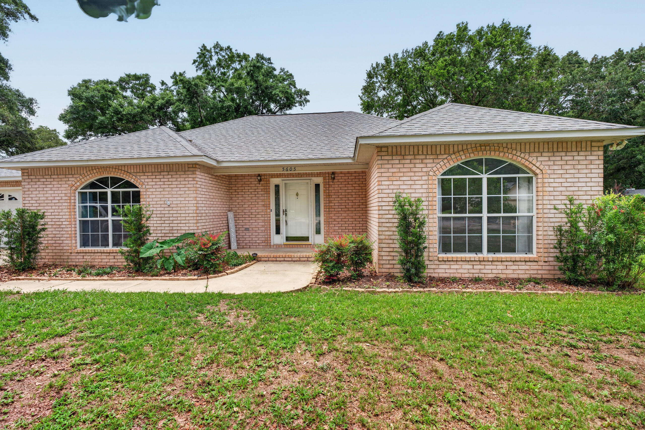 Welcome home to this beautifully maintained all-brick home nestled on a quiet cul-de-sac in one of Pace's most desirable locations. Offering nearly 2,000 square feet of living space, this 3-bedroom, 2-bath home features a spacious split-bedroom floor plan designed for both comfort and functionality.
Step inside to discover neutral flooring, soaring vaulted ceilings, abundant natural light, and an inviting great room centered around a cozy tile fireplace. Architectural details such as decorative wall sconces and plant ledges add character throughout the home. The open-concept layout flows seamlessly into the breakfast area, complete with a built-in desk and glass-front cabinetry--perfect for a home workspace or additional storage.
The well-appointed kitchen offers ample counter space, abundant cabinetry, a breakfast bar, vaulted ceiling, and newer microwave and dishwasher, making meal preparation and entertaining a breeze.
The private primary suite is a true retreat, featuring a spacious bedroom, oversized walk-in closet, built-in storage, a relaxing garden tub, and a separate walk-in shower. Two additional bedrooms and a full bath are thoughtfully positioned on the opposite side of the home for added privacy.
Outside, enjoy year-round relaxation on the oversized deck overlooking a beautifully wooded backyard with mature hardwood trees, a privacy fence, and a convenient outbuilding for extra storage. Conveniently located near Five Points, shopping, dining, schools, and everyday amenities, this home combines a peaceful neighborhood setting with easy access to everything Pace has to offer.

Updates include a New Roof (2022), Flooring (2022), Microwave and Dishwasher (2022), a newly installed HVAC system (2025), and a Septic Tank serviced in 2024-2025, offering added peace of mind for the next owner.

Don't miss this opportunity to own a move-in-ready home in a highly sought-after location.