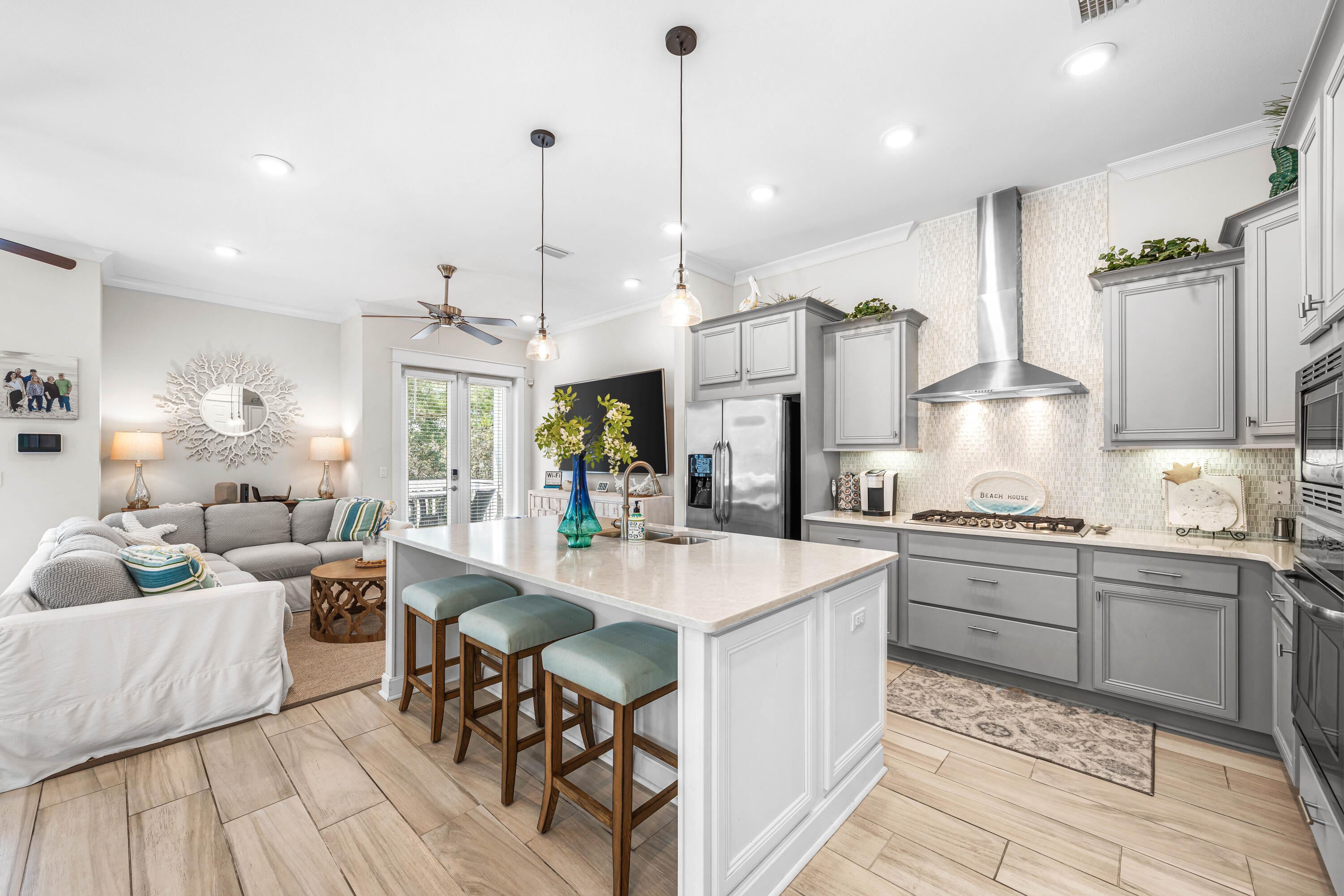 Positioned in one of the most coveted locations in Prominence North, this former model townhome backs to a wooded preserve, sits at the very entrance of the community, and is directly across from the resort-style pool and The Big Chill, delivering unmatched walkability and immediate access to everything that makes Prominence one of 30A's most desirable resort communities. This immaculate, never-rented 3-bedroom, 2.5-bath townhome with a 2-car garage features the only separate garage door entrance in the community and is offered fully furnished with a 6-seater golf cart. Turnkey with strong rental projections, it presents an exceptional opportunity for short-term rental income, a second home, or full-time coastal living. The highly sought-after A Unit floor plan is the largest and most open layout in Prominence North, filled with natural light and thoughtfully designed for effortless everyday living and entertaining. Quality craftsmanship and high-end finishes are showcased throughout, including 8-foot doors, 10-foot ceilings, quartz countertops, a large custom island, mosaic tile backsplash, stainless steel appliances, a gas range, shaker-style soft-close cabinetry, and two sets of French-style doors that open to the spacious private patio. Upstairs, two guest bedrooms share a full bath, while the spacious primary suite features a luxurious ensuite bath and walk-in closet, creating a comfortable and private retreat at the end of the day. Prominence is a community that blends coastal resort living with modern conveniences making it an essential community along South Walton's Scenic Highway 30A. Prominence offers low HOA fees and is centrally located along 30A next to Watersound Beach, between Seaside and Alys Beach. Residents and guests will enjoy access to two resort style pools (with one heated seasonally), The Big Chill, start park trails, bike paths, as well as premium shopping and dining and quick access to the gorgeous Deer Lake State park Beach access and rare coastal dune lake.
