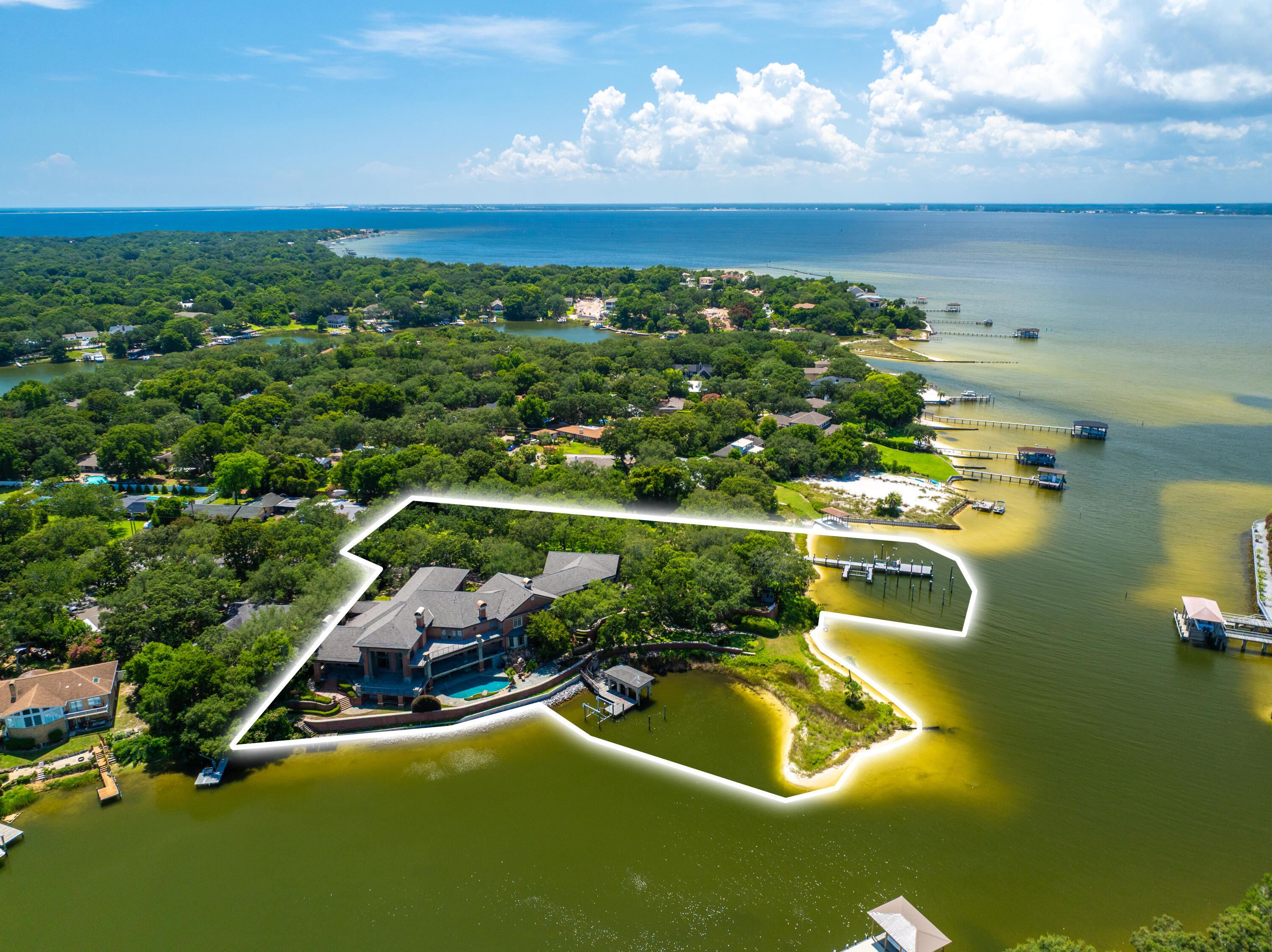Rare opportunity to own 2.98 acres of premier waterfront property stretching from Pensacola Bay to Hoffman Bayou. This unique offering provides both expansive open-water views and protected bayou access--ideal for boating and a true coastal lifestyle. The property includes two deep-water docks, allowing for multiple vessels and easy access to the Gulf. A luxury estate home is already in place, offering the opportunity for renovation or reimagining into a private waterfront retreat. The depth and scale of the lot also allow for a family compound or potential development opportunity. Properties with this size, dual-water frontage, and existing infrastructure are increasingly rare along the Gulf Coast. Also see MLS 972989 & 990457