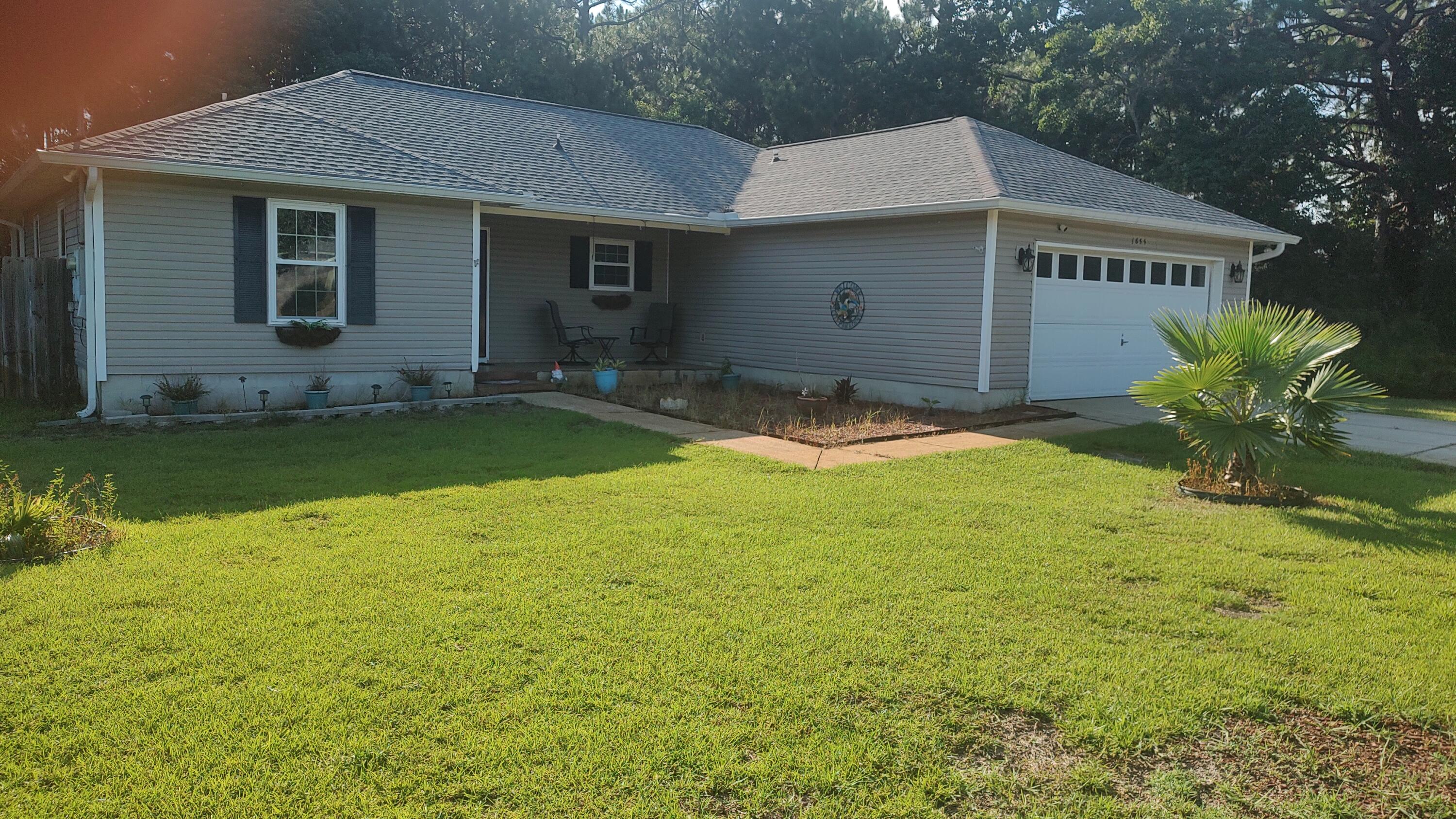 BACK ON MARKET  NOT FAULT OF SELLER OR LENDER. Enjoy the facilities at Holley By The Sea Recreation Area, then proceed to Eagle Lane, your residence which includes a spacious 12' by 22.5' Florida room. a covered porch/patio11.5'X 15 Vinyl flooring with a wood-look finish, and removable windows and screens added in 2024.  New Roof 2020. The home features updated windows from 2021 and vinyl wood-look flooring installed in 2023.   The kitchen is equipped with a stainless-steel side-by-side refrigerator, a nearly new black stove, a black dishwasher, a black microwave, and various other recent enhancements.   All-new plumbing was installed in 2025. Additionally, a new heat pump was added in 2021, thus ensuring comfortable temperatures throughout the seasons.  Leaves are no problem as 2021 leaf filter sits near roof. This property features.. An inviting tiled front porch ideal for enjoying views of the neighborhood. The fenced back yard includes a sprinkler system, two landscaped flower beds, and a covered open patio that adjoins the Florida room. together they provide an excellent space for dining and relaxation. Did I mention cathedral ceiling in both the living and dining rooms. the two French doors or two walkin closets in the Master bath, a built in kitchen island, a great storm door at the entrance is also included. This neighborhood is very walable for a casual stroll.
