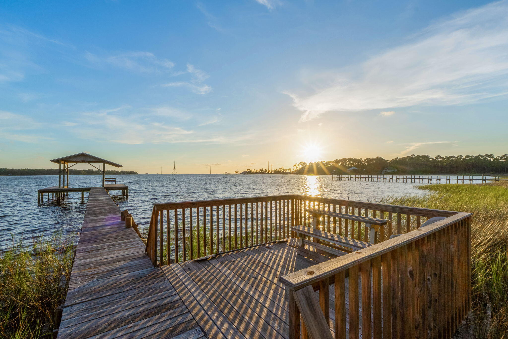 Are you ready to vacation every single day? Have you dreamed of living on the water where you can build your waterfront home with a porch overlooking the water. You could sit on the porch and watch the most incredible sunsets each evening. Fish off the dock. Add a lift to the boat house so at the flip of a switch you can lower your boat and be cruising in minutes. You can watch the dolphins play in the water. See the bald eagles and ospreys flying by. All this plus this waterfront lot is at the end of the street for added privacy. The dock and boat house are in place now. The lot has majestic trees that provide dappled shade during the summer months. There is an easy walking path to get down to the dock and so you can envision where you can build. You would probably need to build on pilings and then you would get incredible elevated views of the bay! Navarre beach is about 15 minutes drive away. Where Y'at Seafood could be your local! 5 minutes to Holley boat ramp. This is a very special location and an amazing opportunity to be on vacation every single day!
