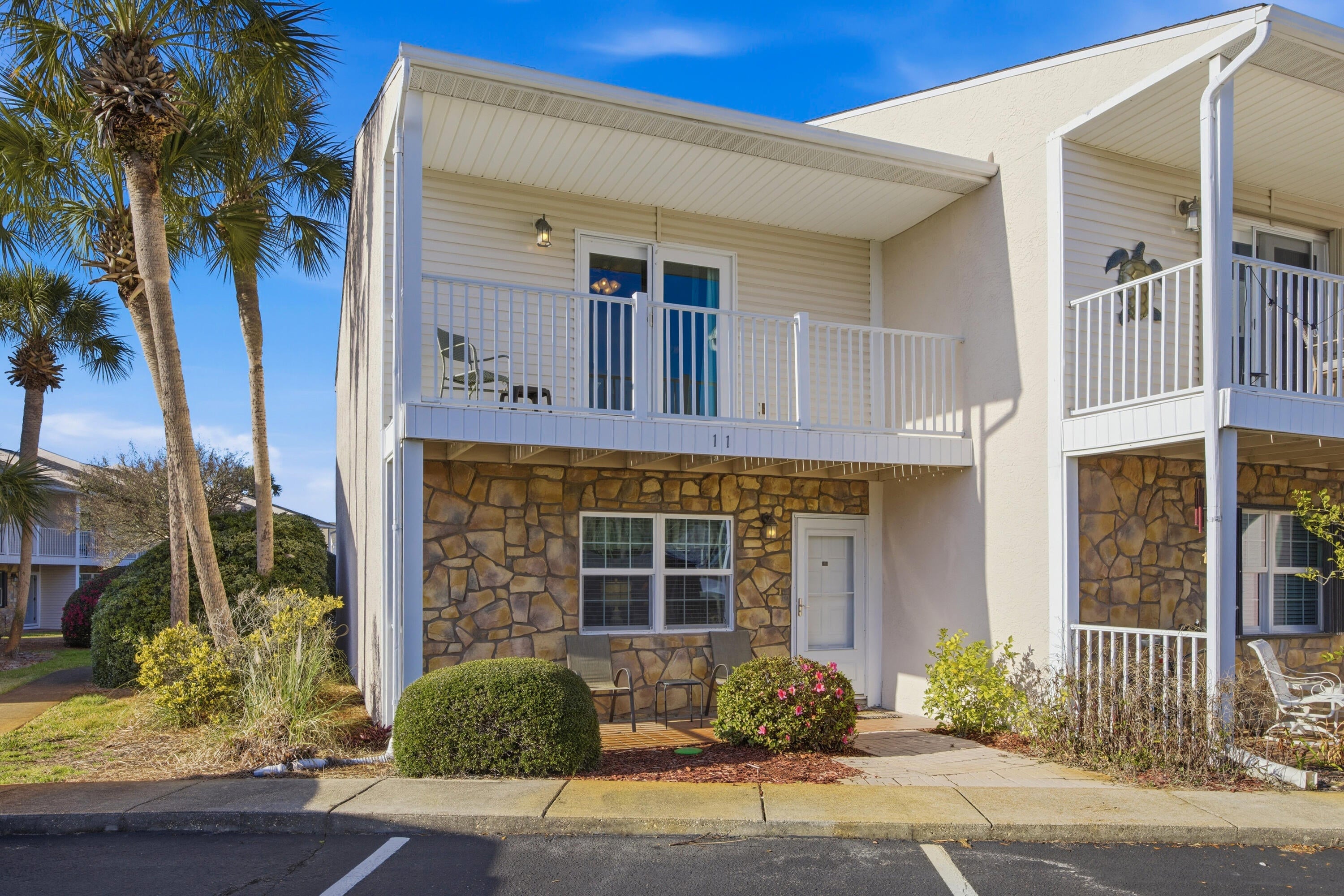 Maximize your portfolio with this fully furnished, turnkey investment property located just a short walk from the white sand and clear blue waters of Miramar Beach. Prime location and zero setup hassle make this two-story townhome ideal for short-term rental income or a low-maintenance vacation property.
The ground floor is built for high guest turnout, featuring an easy-to-clean tile layout, an open-concept living and dining area, a tropical ceiling fan, comfortable seating, and a 50-inch smart TV with a stand. A covered front porch with a stacked-stone exterior offers immediate curb appeal for online listings and incoming guests.
Upstairs, two private bedroom suites with durable wood-look flooring maximize guest capacity and comfort. The main suite includes a king bed (with a mattress and box spring replaced in 2025) and opens to a private balcony, while the second suite features a queen bed (mattress and box spring replaced in 2015). With all furnishings and essentials already in place, you can start booking guests and generating revenue from day one.