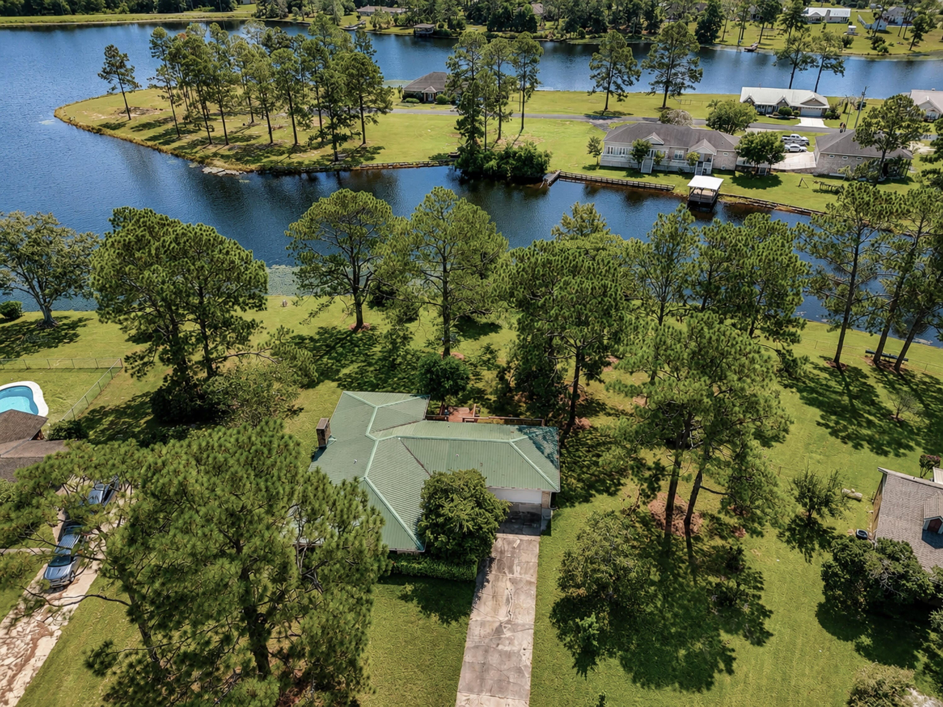 Spacious WATERFRONT brick home on nearly 1 acre with just shy of 200 feet on the water and stunning views - all in a community with NO mandatory HOA in popular Ten Lake Estates! This home was made for someone who truly appreciates a move-in ready home - and especially the outdoors. The landscaping is lush, with a to-die-for porch totaling appx 400SF with panoramic east facing views of the water for amazing sunrises - plus 700SF of deck! With one floor and spacious rooms throughout, this updated home has been excellently well maintained. The kitchen features granite counters, stainless appliances and crisp white cabinets. The adjacent living room showcases a brick fireplace with views through the porch to the water. Easy care updated tile flooring can be found throughout, with only the bedrooms carpeted. The huge master suite is outfitted with an updated tile shower, jetted tub with granite surround and a granite top double vanity. The laundry room is extra large, perfect for extra storage we all so desperately need - plus more storage in the pantry! Both of which are just off the garage for convenience. The sprinkler system is fed by a well, saving you greatly. The metal roof (estimated 2014) was outfitted with new Zac screws to keep you safe and dry. There is an optional HOA for those who wish to enjoy fishing in all the lakes for only $100 per year. This is the total package