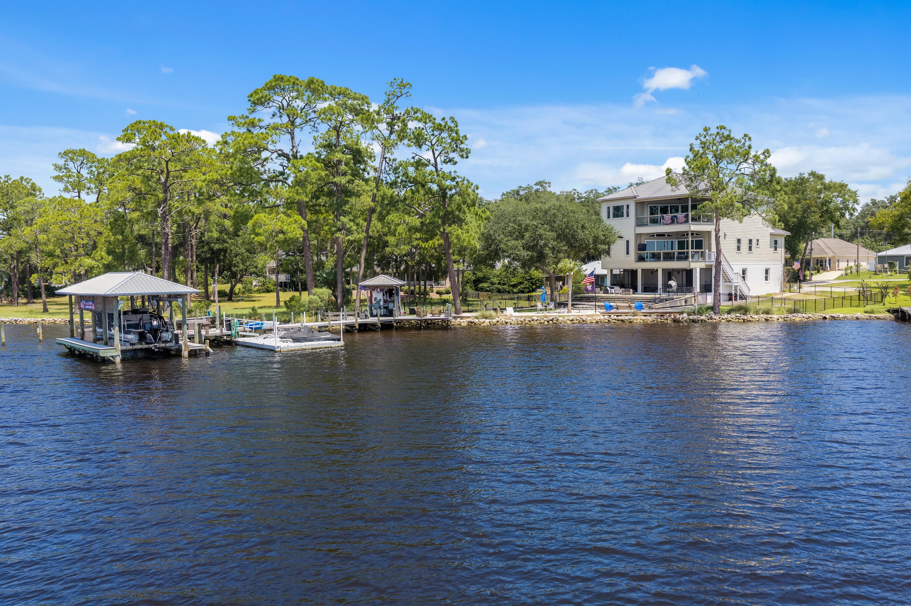 Turnkey waterfront living in Niceville! You can unwind to sunsets from nearly anywhere in this custom-built waterfront estate at 1027 Christy Drive - with a front-row seat to July 4th fireworks and a 20-minute boat ride to Destin. Deep-water dock with flow-through decking, covered boat lift, jet ski and kayak launch. Elevator serves all 3 levels. 1st floor: kitchen, half bath, multi-purpose room, 2 oversized garages, built-ins. 2nd floor: water-view kitchen and living area, screened porch, large balcony, 3 bedrooms, 2 full baths, laundry. 3rd-floor primary suite is a private oasis with kitchenette, private balcony, office and stunning views. Upgrades include a full-house generator, well-fed sprinklers, outdoor shower, 2 HVAC systems, 2 tankless water heaters, central vacuum, fresh interior and exterior paint, custom cabinetry, hardwood floors, foam insulation, gas grill hookup, new tile flooring, new snap-jacketed and wrapped pilings (deteriorated ones replaced), new stairwell to ground level, new circular drive, hardscaped front and back yards, and fencing along the entire waterside property. Did I mention the putting green?
BONUS: all water toys included at no added value - 2023 Barletta Coastal Edition pontoon, 2024 Sea-Doo Explorer 170, Sea-Doo GTX 300 (PWCs), and tandem trailer. 
Don't miss this one-of-a-kind waterfront lifestyle!
Schedule your private showing.