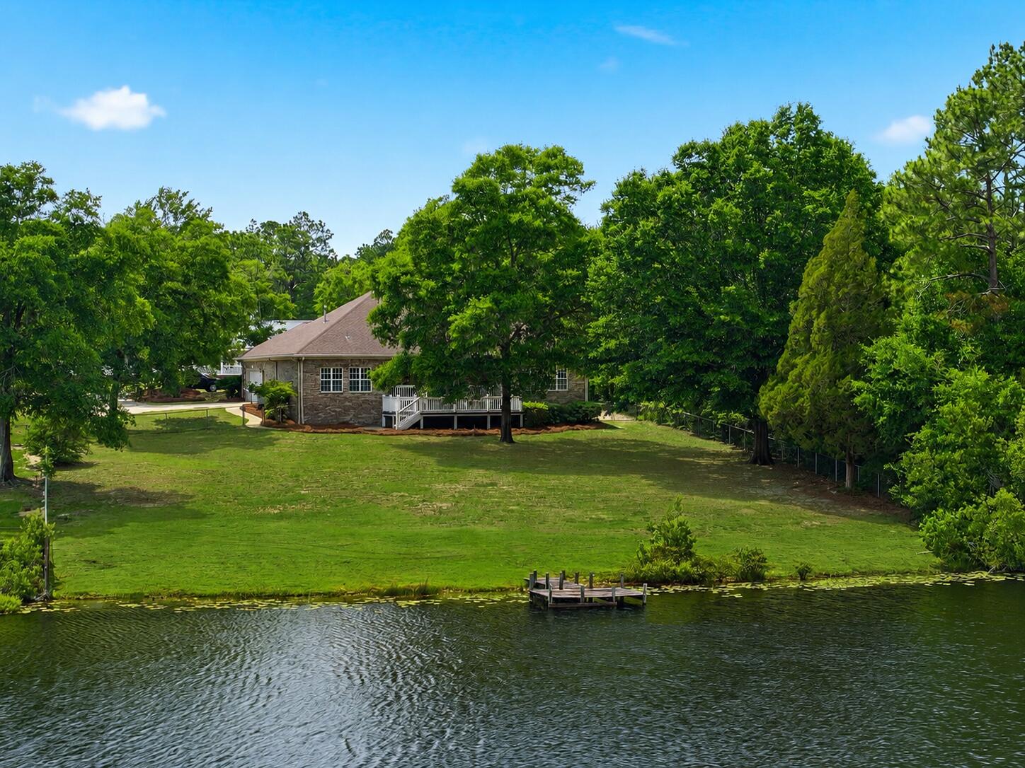 Custom built and thoughtfully designed, this 3 bedroom, 2 1/2 bathroom lakefront home offers over 2,200 square feet of comfortable living tucked away in the quiet Hidden Lakes community of DeFuniak Springs. Perfectly placed windows fill the home with natural light while capturing lake views from nearly every room. Situated on an oversized lot with a private dock, covered back porch, and extended outdoor entertaining area, this property was designed to enjoy the beauty of lakeside living.

Inside, you'll find fresh paint, new carpet in the bedrooms, and new refrigerator, as well as a new roof and water heater. The kitchen features custom cherry cabinetry, while the living room showcases natural hardwood flooring, a gas fireplace, and a custom built media center that creates a warm and inviting focal point. Additional details including custom trim work and crown molding add character throughout the home.

Whether enjoying your morning coffee overlooking the Lake or unwinding after dinner on the back porch, this home offers a peaceful setting that is hard to find.