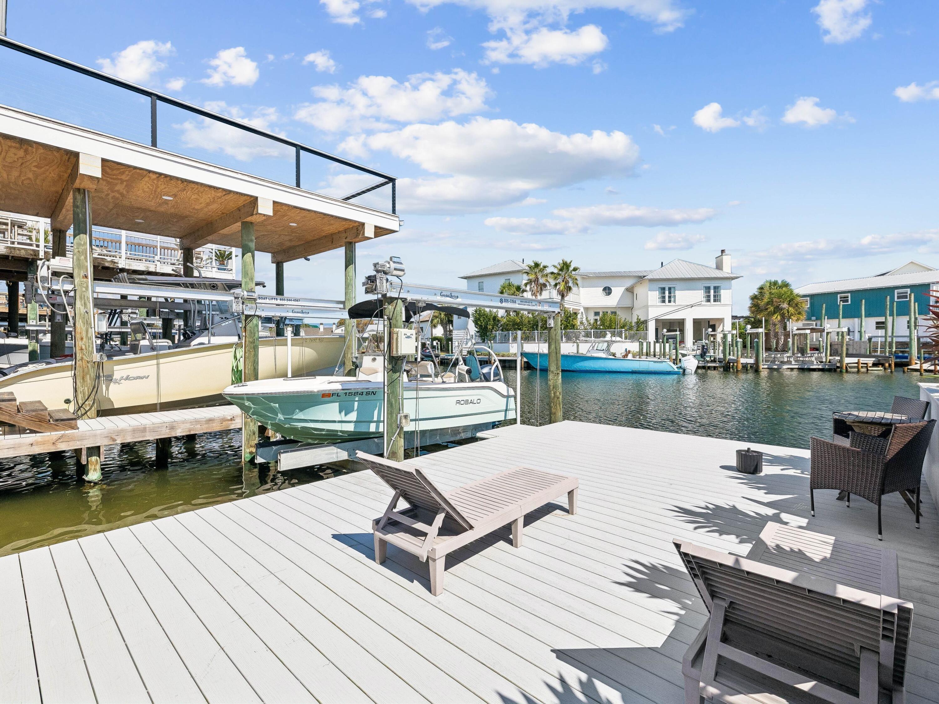 Life on the harbor takes center stage at this renovated waterfront townhome, where a deeded 40-foot boat slip with lift places days on the water just steps from home. Set along the protected canals of Destin Harbor with nearby private beach access, the turnkey residence offers an exceptional setting for those who want boating, beach days and refined coastal living within easy reach.

Spanning 1,558 square feet across two thoughtfully designed levels, the three-bedroom, three-bath custom townhome has been meticulously updated throughout. Vaulted ceilings and exposed beam detailing bring architectural character to the bright, open living and dining areas, while hardwood and tile flooring, custom furnishings and curated coastal décor create a polished yet relaxed atmosphere.

The renovated kitchen is designed for everyday living and entertaining, with stainless steel appliances, ample cabinetry, a generous breakfast bar, and modern lighting. Its open connection to the dining and living areas keeps the waterfront lifestyle at the heart of the home.

Two levels of outdoor living extend the residence toward the harbor. A covered water-level patio provides a shaded retreat just steps from the private boat slip, while an expansive upper deck with a built-in grill station offers generous space for alfresco dining, entertaining and enjoying the harbor breeze.

The first-floor primary suite features direct access to the outdoor living area, a custom closet system and an updated bath with a soaking tub, glass-enclosed shower and designer tile work. A split-bedroom floor plan provides privacy for family and guests, with two additional bedrooms and two full baths completing the layout.

With direct water access, a deeded 40-foot boat slip with lift, private beach access and a comprehensive renovation, this harborfront residence offers a turnkey opportunity for full-time waterfront living or a sophisticated coastal retreat centered around life on the water.