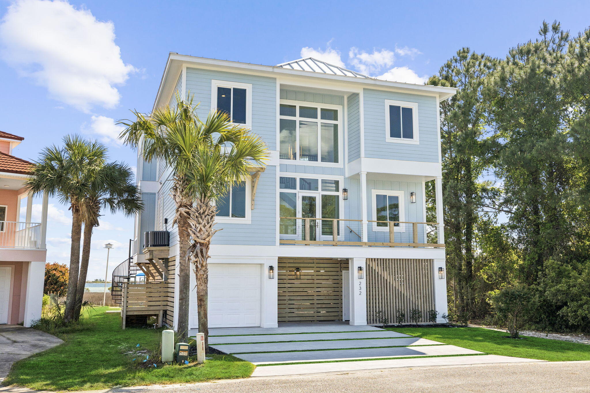 Stunning coastal new construction in a gated cul-de-sac waterfront setting with private sand beach and dock (permit in final stage). This 5BR + office, 4.5BA home features PGT hurricane windows/doors, white metal roof, Hardie board siding, and wood pilings with cross-bracing. Interior boasts white oak floors, Crossville tile baths, designer mosaics, and luxury stones including Bianco Impala marble, Cristallo quartzite, and Carrara marble. Chef's kitchen with Forno gas range and SS appliances. Grand 21' entry with statement chandelier, wine display, and custom millwork. Navien tankless WH, app-controlled irrigation, outdoor shower, large garage, and room for a pool complete this coastal retreat.