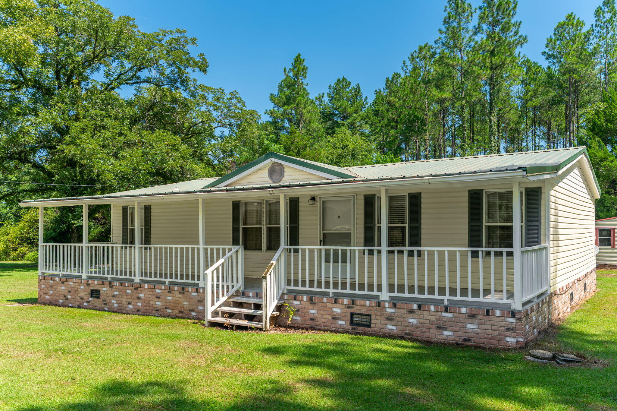 Welcome home to your own storybook country retreat, tucked away on 3.21acres in Baker! A large front porch sets the tone--made for rocking chairs, sweet tea and slow mornings--while the back porch offers another inviting spot to relax and enjoy the quiet surroundings. Inside, the open-concept living area feels warm & welcoming with new LVP flooring and crown molding throughout. The kitchen features all appliances less than a year old, a center island with plenty of space for meal prep, casual dining and conversation, beautiful cabinets for storage. The primary suite offers a private en suite bath with double vanities and a spacious closet. The guest bath features a convenient walk-in shower. Outside is where country living really shines! There's room to spread out, garden, entertain or simply enjoy the privacy of acreage. A storage shed with power provides space for projects, tools and extra storage, while covered parking offers protection for recreational vehicles, lawn equipment, boats or other outdoor toys. If you're country at heart and dreaming of a little more land, a little more privacy and porches made for unwinding, this charming Baker property may be just the place to call home.  Being Sold 'as is'
