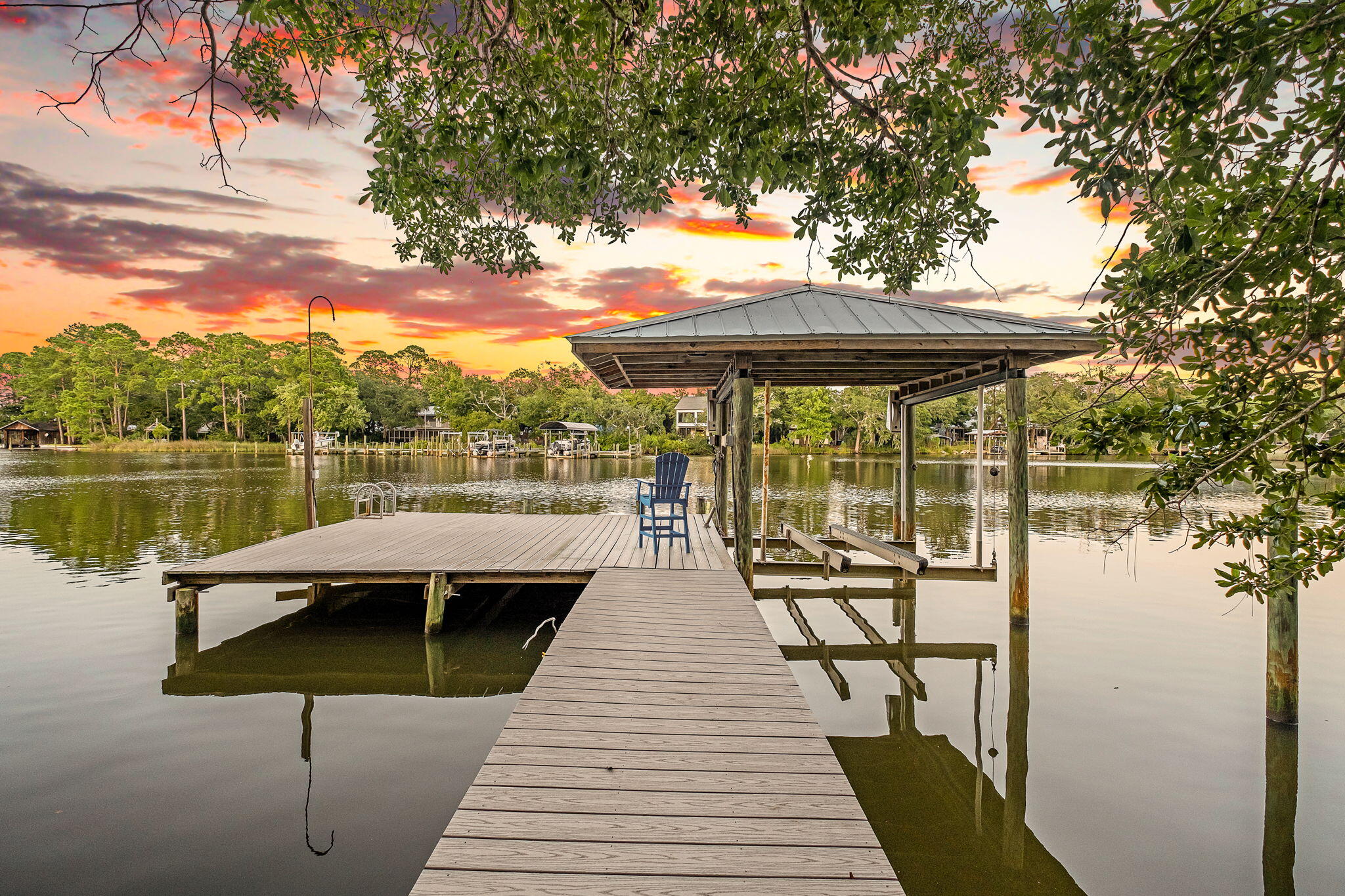 A rare waterfront retreat where privacy, panoramic bayou views, and timeless Mid-Century Modern architecture come together on 1.5 acres of pristine waterfront. Perfectly nestled among towering trees and fan palms, this exceptional bayou-front home offers a setting that is nearly impossible to replicate. According to the seller, current regulations no longer allow homes to be built this close to the water, preserving the spectacular views that stretch across the entire back of the property. Originally built by local builder Thomas Stoffels (builder of the Donut Hole), this thoughtfully designed home offers approximately 2,750 square feet with 4 bedrooms and 3 full bathrooms, including a private guest or in-law suite that can be separated from the main living area. Stunning bayou views fill the primary bedroom, great room, dining area, and the attached gazebo office/sitting area, creating a seamless connection between the home and its peaceful surroundings.

Extensively updated, the home features fresh interior and exterior paint, new LVP flooring, new carpet in two bedrooms, a newly added third full bathroom, second bathroom renovation, new pool screens, new sliding patio doors, a new electric pool heater, new privacy fencing, and an expanded dock with Trex decking and a covered boat lift.

Step outside and experience the waterfront lifestyle you've been dreaming of. Launch your paddle board or kayak from your private dock, spend the afternoon fishing, or enjoy an approximately 30-minute boat ride to Destin Harbor. Start your mornings watching dolphins swim by from the screened porch and end your evenings beneath brilliant star-filled skies from your own private retreat.

The attached two car garage includes a workbench, utility sink with hot and cold water, and attic storage, the additional single car garage provides abundant storage, shelving, and workshop space. A covered fish-cleaning or gardening station with a working sink adds even more convenience. The property is also zoned for a second story, offering future expansion opportunities on the main home or additional building options on the large piece of land.

With deep-water access, exceptional privacy, breathtaking views, and a location that cannot be duplicated, this is a truly one-of-a-kind waterfront property offering a lifestyle as remarkable as the home itself.