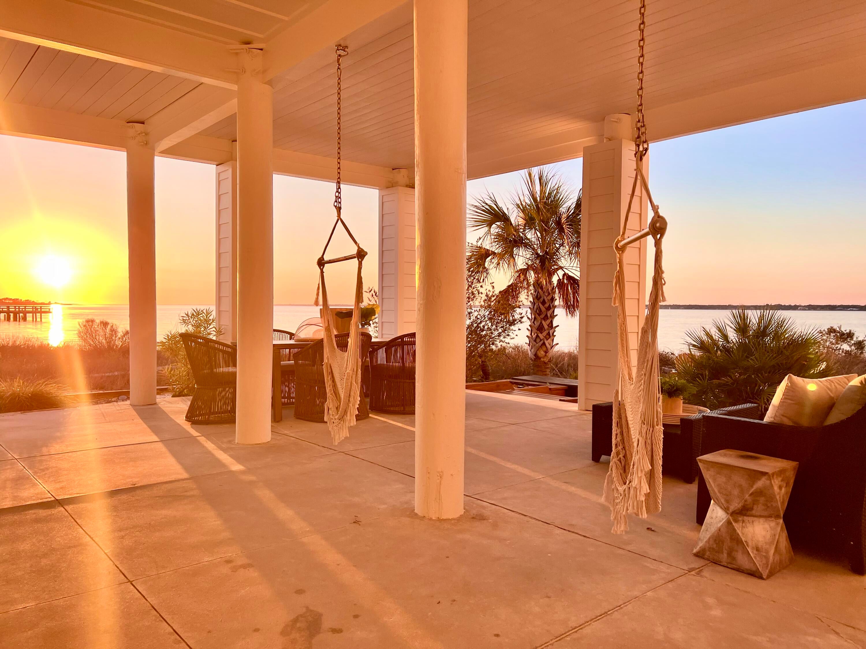 Experience serenity inside and out of this stunner! Discover luxurious island living in this beautiful waterfront home on Navarre Beach, perfectly situated on a white sandy beach with breathtaking water views of Santa Rosa Sound from every window. Nestled in the quaint, gated 'By the Sea' community, this professionally interior-designed, fully furnished luxury beach house offers the ideal retreat or smart rental investment. This customized home features two oversized ensuite bedrooms, each with a private balcony, along with two large guest rooms and two versatile bonus rooms—perfect for a variety of needs including additional sleeping space. The ground level includes an approximate 600 sf of gorgeously finished, air conditioned space with a full bath, creating the possibility of use as