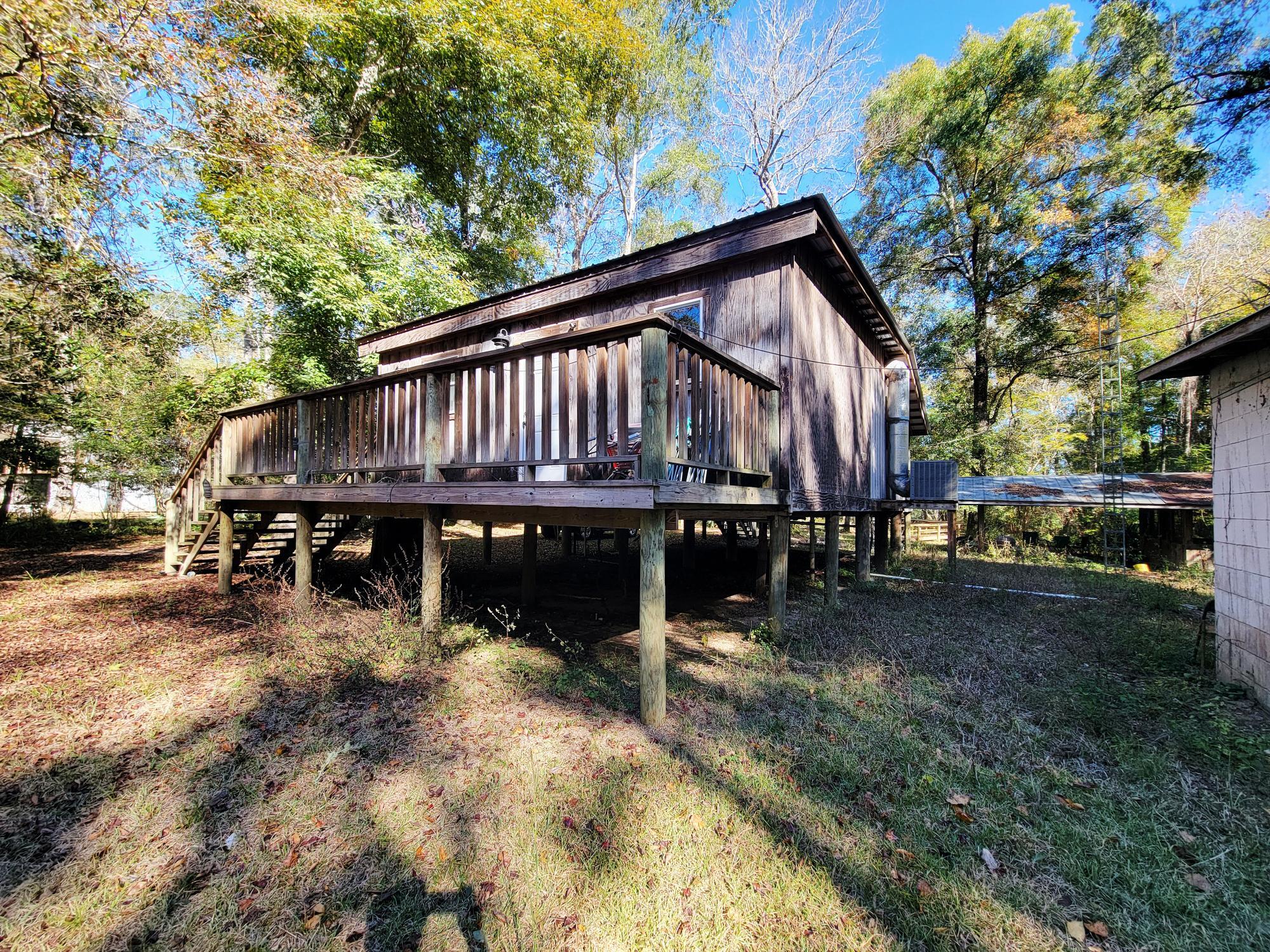 Nestled on 1 acre along the Choctawhatchee River in Walton County, this 2-bedroom, 1-bath cabin offers an old Florida tropical feel and a nature lover's paradise. Fully furnished with an open front porch, covered rear porch, large separate covered and partially screened patio for entertaining, dock, and new metal shed/garage, small block outbuilding. Off a winding freshly paved road surrounded by mature trees & right near a county boat ramp, freshwater springs; river eventually  leads to the Choctawhatchee Bay & Gulf of America. The lot has a small portion across the street from the gate entrance for additional parking. Approximately 50 minute drive to the beach. Buyer to perform own due diligence.