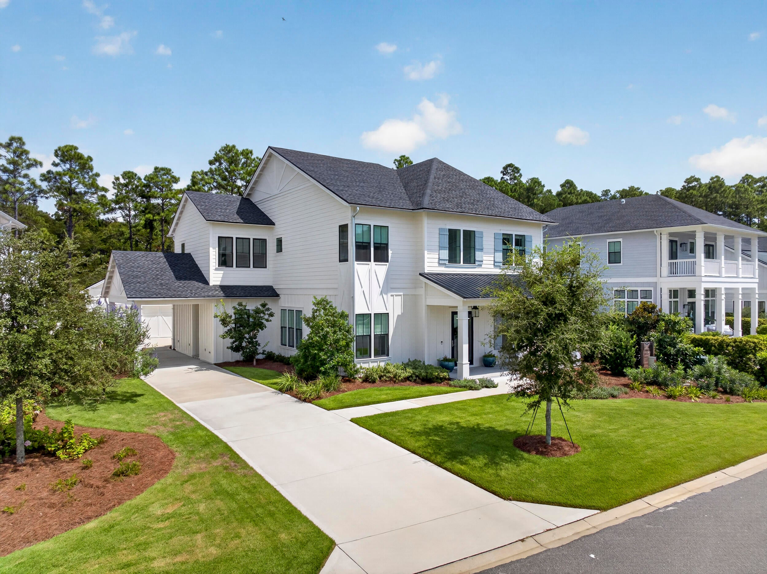 Built by the renowned Arkon Group and ideally positioned within the coveted Greenway neighborhood of Watersound Origins, this exceptional 5-bedroom, 4.5-bath residence offers a refined blend of coastal elegance, thoughtful design, and effortless indoor-outdoor living. Mere steps from Origins Golf Club and backing to a tranquil nature preserve, the home enjoys peaceful wooded views and a heightened sense of privacy rarely found in a community setting.
From the welcoming front porch with its charming gas lantern to the expansive interior, every detail reflects the craftsmanship and attention to design synonymous with Arkon homes. The spacious floor plan features dual primary suites, a dedicated home office, upstairs media room, two laundry rooms, and abundant living space designed for both everyday comfort and entertaining.
The first floor showcases one of the home's two luxurious primary suites, a private office, separate dining area, and an inviting Great Room anchored by a gas fireplace and framed by French doors opening to the outdoor living area. A stylish wet bar is conveniently positioned between the dining area and kitchen, creating an ideal setting for entertaining. The chef's kitchen is beautifully appointed with Thermador stainless steel appliances, custom wood cabinetry with soft-close doors, quartz countertops, and generous workspace. Upstairs, three guest bedrooms are complemented by a spacious media room, second laundry room, and the home's impressive second primary suite. The upper-level primary suite offers access to one of the home's three covered porches, providing a peaceful retreat surrounded by the natural beauty of the preserve.
The outdoor living spaces are equally impressive. A large screened lanai features a custom wood ceiling, porch fan, summer kitchen, and dedicated outdoor dining area, creating an inviting setting for relaxed coastal gatherings. Beyond the lanai, the private heated pool with sun shelf provides the perfect place to unwind. With more than 700 square feet of combined covered porch space, there is no shortage of opportunities to enjoy the outdoors in comfort and privacy. A convenient carport and detached two-car garage provide ample parking and storage.
Luxury finishes throughout include 10-foot ceilings, 8-foot solid-core doors, wire-brushed hardwood flooring, quartz countertops in the kitchen and bathrooms, custom tile flooring in each bathroom, custom wood cabinetry, wood closet shelving, designer lighting, and beautifully crafted shiplap accent walls in the office, kitchen, dining area, and living room.
Beyond the residence, Watersound Origins offers an exceptional lifestyle just minutes from the sugar-white beaches and emerald waters of 30A, along with an array of shopping, dining, and entertainment. Residents enjoy access to the Village Commons, featuring a resort-style swimming pool, fitness center, sports courts, Origins Golf Club, parks, and scenic walking trails. With a six-month minimum lease policy, Watersound Origins welcomes both primary and second homeowners, offering the flexibility to enjoy this remarkable property year-round or as a seasonal retreat.
Private preserve setting, exceptional Arkon craftsmanship, dual primary suites, resort-style outdoor living, and an enviable location within Watersound Origins come together to create a truly special 30A-area residence.