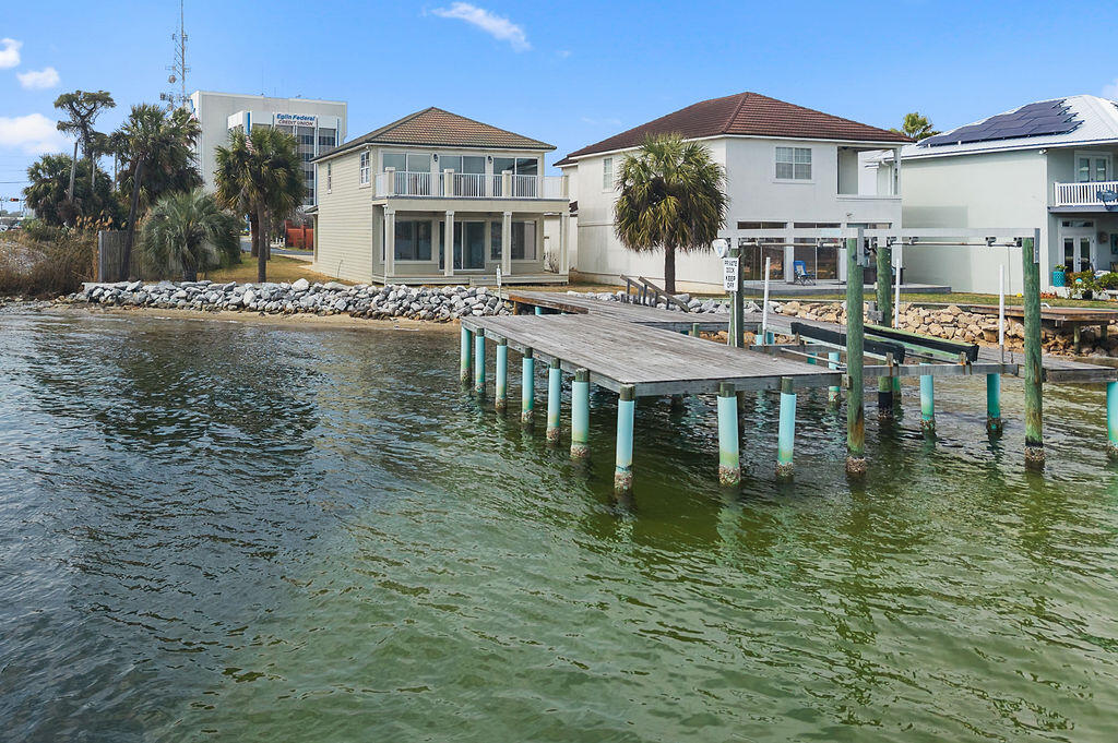 Lighthouse Pointe | Gated Bayou Waterfront | Dock + Boatlift | Largest Lot + Driveway

Tucked inside the upscale gated waterfront enclave of Lighthouse Pointe -- comprised of just 15 prime waterfront homesites -- 901 Lighthouse Road presents a rare opportunity to secure private coastal living just in time for boating season. Now beautifully refreshed and thoughtfully upgraded, this move-in-ready residence blends luxury, comfort, and peace of mind. Recent improvements include Hardiboard siding on the southern exterior wall (2023), fresh interior paint and kitchen cabinetry refinished in a crisp white (late 2025), luxury vinyl plank flooring throughout the main living areas, and three remodeled bathrooms (2015). Major mechanical updates include a tankless gas water heater, and a second HVAC system added in 2018 to provide independent climate control for both upper and lower levels. Rear sliding doors leading out to both decks were replaced in 2017, enhancing energy efficiency and seamless indoor-outdoor flow. Together with a metal roof, well-maintained stucco siding, a rebuilt dock in 2020, and a thorough recent spring glow up, you'll be ready to move-in! 
Designed to embrace the Emerald Coast lifestyle, the expansive open-concept main living level is filled with natural light, 10-foot ceilings on the main level, and generous entertaining spaces ideal for sunset gatherings after a day on the water. The oversized kitchen is truly a showpiece, featuring commercial-grade stainless Viking gas range, wall oven and microwave, $13K Sub-Zero refrigerator, Bosch dishwasher, expansive granite surfaces, recessed and under-cabinet lighting, separate pantry, home organization station, and an oversized island with seating -- all framed by sweeping waterfront views. Natural wood shiplap accents add warmth while maintaining a refined coastal aesthetic. All the bedrooms are thoughtfully positioned upstairs, creating ideal separation between entertaining and private retreat spaces. The oversized primary suite is a sanctuary overlooking the water, complete with private balcony access, spa-inspired bath featuring a freestanding soaking tub, rain-head walk-in shower, custom vanity, and fully built-out walk-in closet. A spacious sitting area and dedicated desk nook offer flexibility for relaxation or remote work with serene bayou views. Secondary bedrooms are generously sized -- one large enough to accommodate multiple queen beds and bunks -- ideal for hosting family and guests.
Outdoor living is where this property continues to stand apart. The expansive yard -- the largest in Lighthouse Pointe -- offers the rare combination of private dock access, boatlift, and usable green space. Enjoy sunrises from the upper balcony, alfresco dining beneath the covered patio, convenient outdoor shower after beach days, and an oversized two-car integral garage with ample storage for boating and beach equipment, and long driveway.
Positioned just off Eglin Parkway at the foot of the Shalimar bridge on Garnier's Bayou, this home offers the rare combination of gated privacy, direct water access, and true in-town convenience -- centrally located between Eglin AFB and Hurlburt Field, with beaches, dining, medical facilities, shopping, and Destin-Fort Walton Beach Airport just minutes away. No long commutes anywhere! 
Now reintroduced to the market for the spring and summer season, 901 Lighthouse Road represents compelling value within one of Fort Walton Beach's most intimate and desirable waterfront neighborhoods. Prior appraisal (2023) at $1.1M available upon request. 
This is Emerald Coast waterfront living at its best-- REFRESHED, REFINED, and READY!