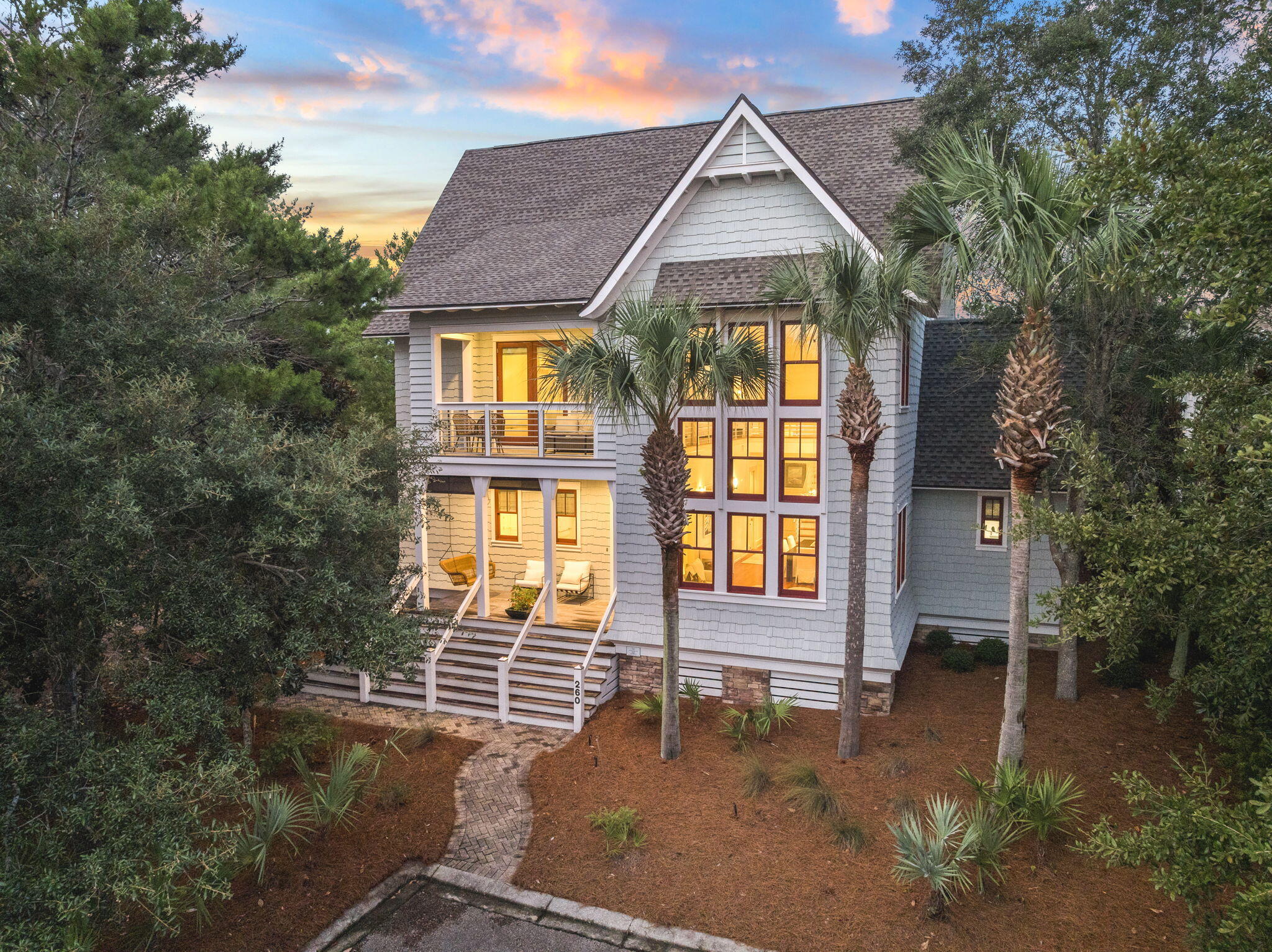 Tucked away within the private Peninsula section of WaterSound Beach, 260 Gulf Bridge Lane sits on an unusually large, wooded homesite just moments from Camp Creek Lake and the Gulf. The Nantucket-inspired architecture feels timeless, while 22-foot ceilings and beautifully placed transom windows fill the home with natural light. Bolivian rosewood floors, Italian marble and exotic wood cabinetry bring warmth and character to the interiors.

The open kitchen was designed for gathering, with Sub-Zero appliances, double ovens, a wine refrigerator, ice maker and generous center island. The home offers three furnished bedrooms, each with its own ensuite bath. Two guest suites are located on the main level, while the second floor is dedicated to a private primary suite with a balcony and spa-inspired bath.
What makes this property especially compelling is the privacy and possibility it offers. The oversized homesite provides room for a pool, carriage house and two-car garage. Approved plans for the carriage house and a third-floor addition with a fourth bedroom and full bath convey with the home. A new roof was completed in 2024, along with newer HVAC systems.
WaterSound Beach is one of those places that continues to stand apart along 30A. Its private beaches, winding boardwalks, coastal lakes and preserved natural landscape create a quiet sense of beauty that is difficult to recreate. Its central location also makes it easy to bike, walk or take a short drive to Seaside, Alys Beach, Seacrest and Rosemary Beach, placing some of 30A's most celebrated dining, shopping and gathering places within easy reach. This is a home with genuine architectural character, exceptional privacy and the opportunity to make it something truly personal.
