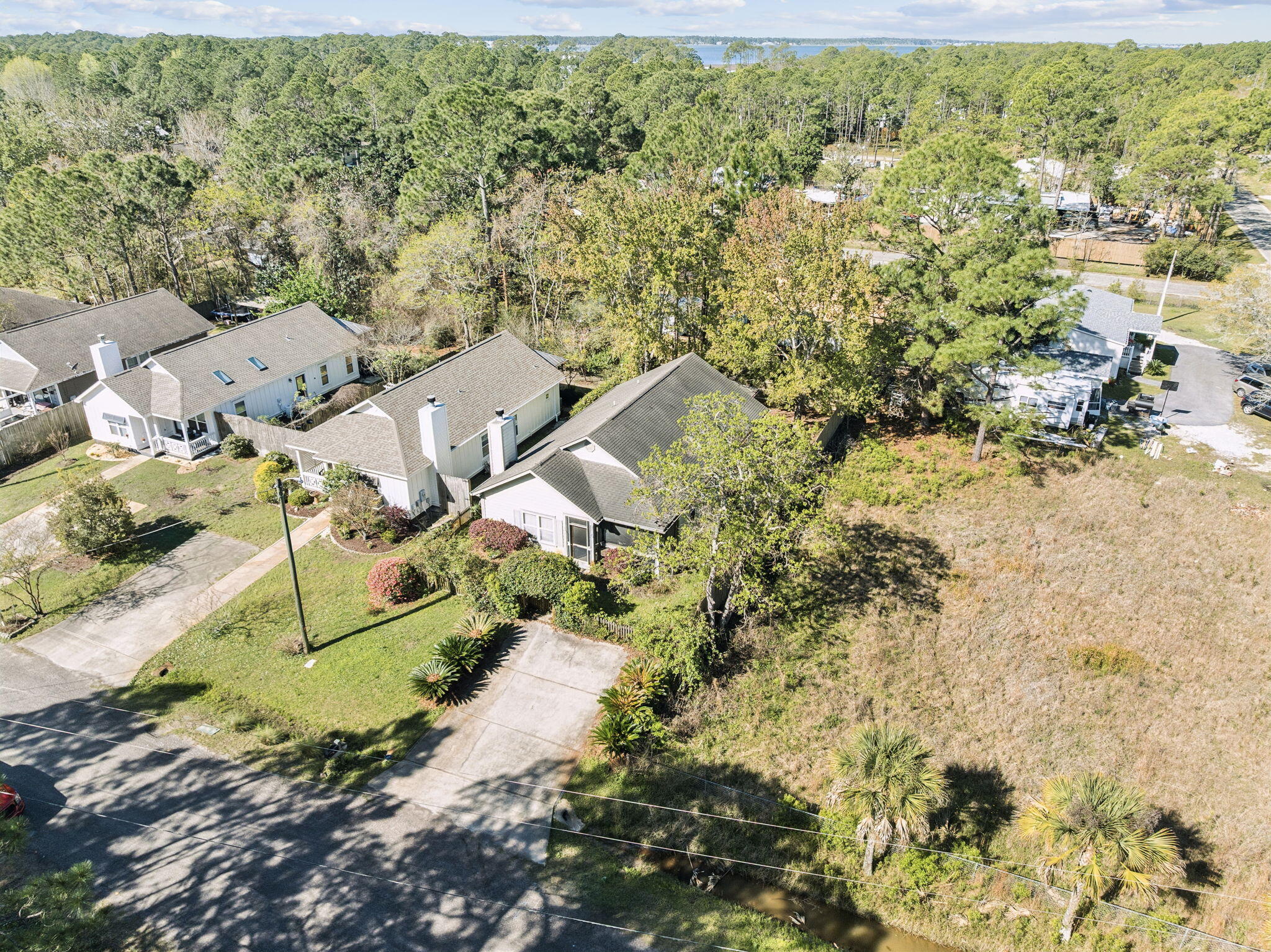 This 3 bedroom, 2 bathroom cottage offers a compelling opportunity in Santa Rosa Beach for buyers ready to make a space their own. A spacious screened front porch welcomes you in, setting the tone for relaxed coastal living. Inside, the main living area features vaulted ceilings and skylights that bring in natural light, along with a kitchen offering cherry cabinetry, stainless appliances, and a breakfast bar. A separate family room centered around a fireplace provides additional flexible living space. The owner's suite includes vaulted ceilings, natural light, direct access to the backyard screened porch, and an ensuite with soaking tub, separate shower, double vanity, and walk in closet. The secondary bedrooms are generously sized and include a closet for ample storage. A laundry room with exterior access leads to a large fenced backyard with room to create your ideal outdoor setup. Located approximately one mile from Cessna Landing, you will enjoy convenient access to a public boat launch, docks, picnic areas, playground, and sports courts. Whether you are seeking a primary residence, vacation retreat, or investment opportunity, this property offers strong potential in a highly desirable Santa Rosa Beach location.