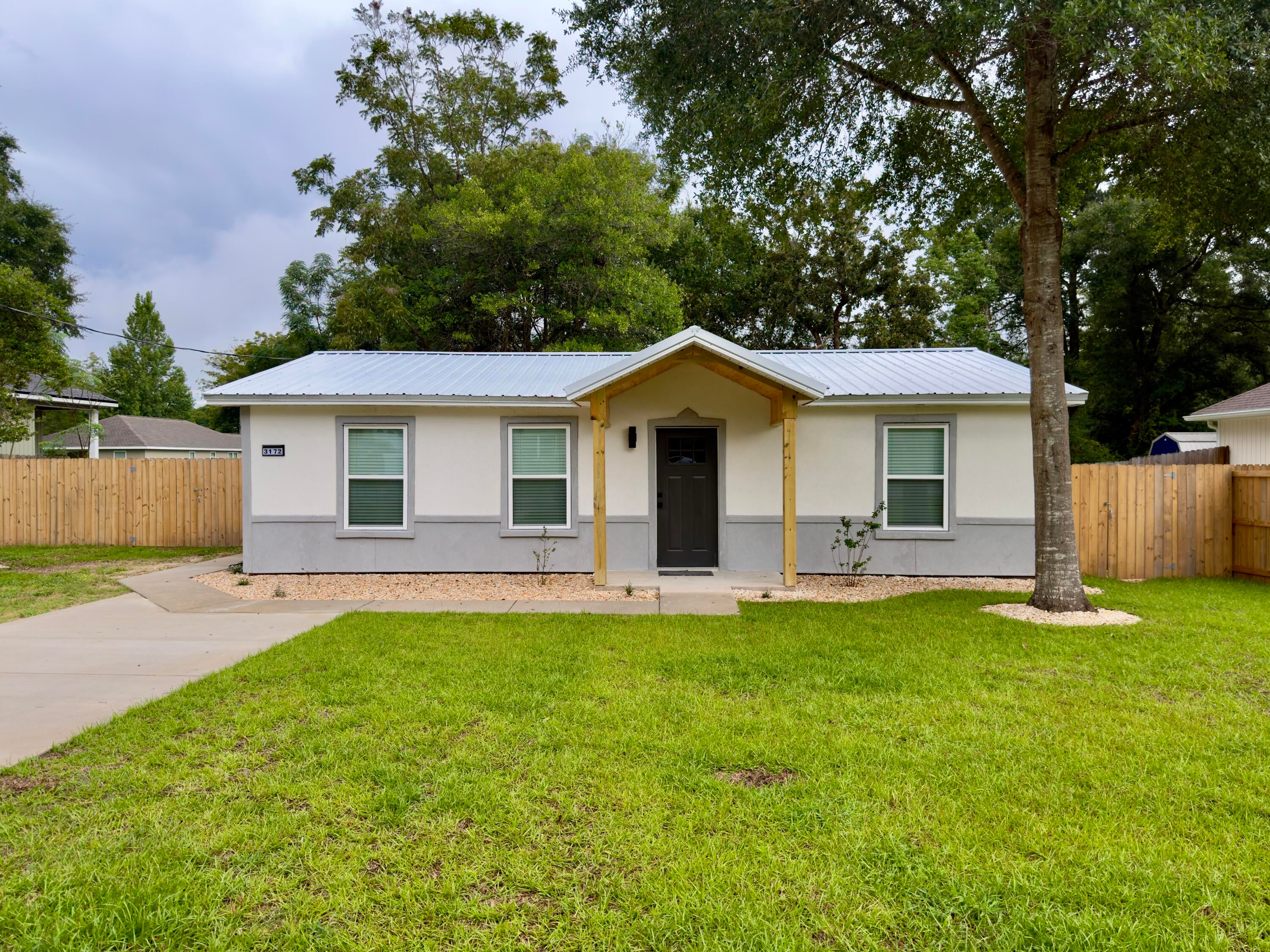 You are definitely going to want to see this property! Wow factor in effect. Beautifully remodeled, this property is just a 6 min drive north from Airport Rd and Hwy 85. Originally built in 1982 but completely renovated in 2026, this home shows like 30a in Crestview. The exterior has fresh siding, metal roof, fenced yard, wood accented porches, recessed lighting in the soffits, rock bed landscaping, stucco mailbox and new drive and walk ways. Fully of updated throughout the interior - the living room has a great room feel with open kitchen, dining, living room concept. Shiplap walls dominate this area with a walk in laundry/pantry just off of the living area. Cabinets are upgraded soft close with white quartz tops. The stainless steel appliances, with upgraded microwave, smooth top stove and ultra quiet dishwasher complete the kitchen. There is a sit down bar area for quick meals. For added energy efficiency, spray foam was added to the attic. The master bedroom is large with raised ceilings with shiplap accents, walk in closet and the master bath has double vanity, tiled shower and a private water closet. This home is a must see! Call today
