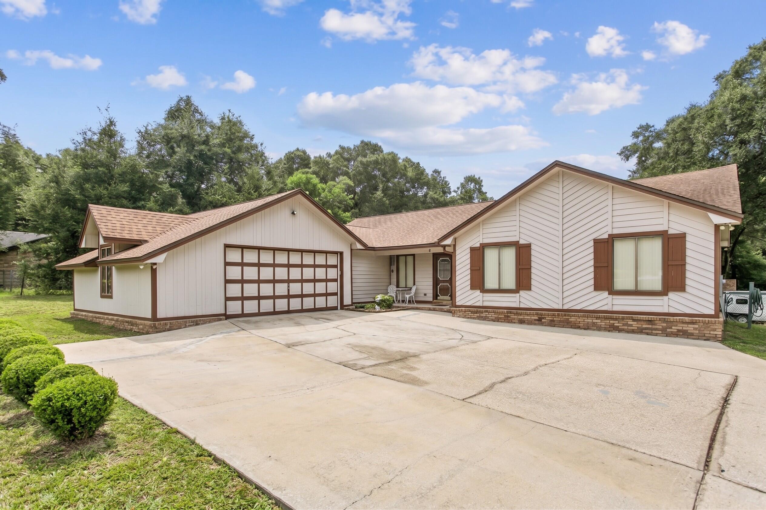 Welcome home to this one-of-a-kind ranch style home in the Kennedy Lakes area of Crestview - an excellent location for local military base commuters and just minutes to downtown, shopping, and dining spots! Offering rare independence and versatility with no HOA! Situated on a 1.08-acre double lot, the home provides significant land, privacy, and functional exterior features. A large, expansive driveway leads to a side-entry garage, offering ample space for guest parking and easy vehicle maneuvering. The residence includes 3 spacious bedrooms, 2 bathrooms, a formal dining room, inside laundry room, kitchen with granite countertops and a breakfast bar, and an open main living area highlighted by exposed ceiling beams and a cozy fireplace as its centerpiece. A climate-controlled Florida room provides a versatile, light-filled space for year-round living overlooking the grounds. Outside, a large detached carport comfortably accommodates a full-sized boat or RV and features a 50-amp electrical plug, ideal for an RV hookup or an EV charging station. Additionally, a detached shed powered with electricity provides an ideal setup for a workshop, studio, or extra storage. The yard is fully fenced-in and features a convenient double gate at the back of the lot for a straight shot to the carport, as well as a great view of the nearby lake! Practicality extends into the home's oversized 2-car garage, which is fully equipped with built-in storage cabinets and pegboards for tool organization. Combining acreage, specialized utility setups, and functional living spaces, this property offers a well-appointed solution for buyers seeking extra land and utility without community restrictions.