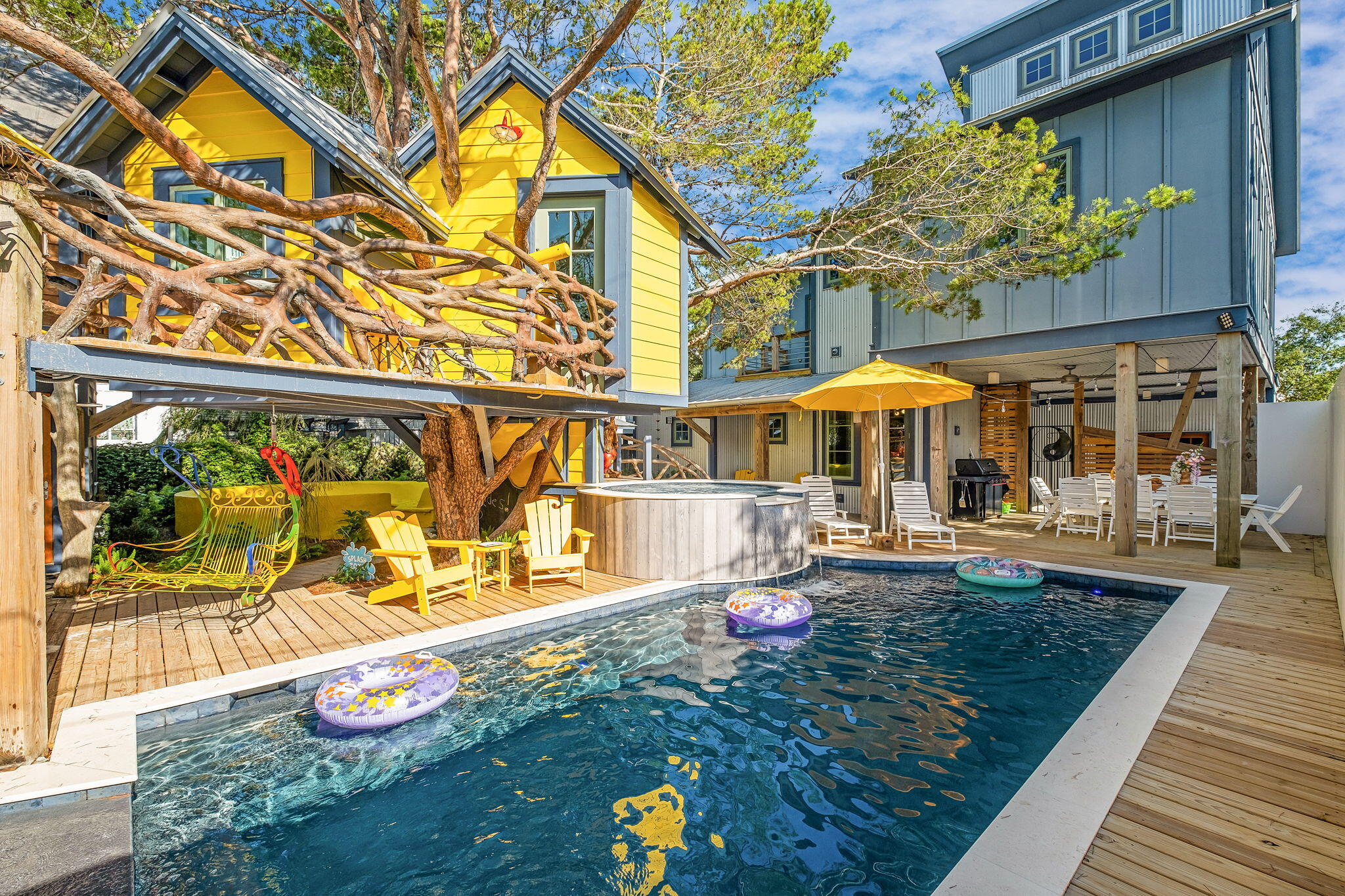 Some homes are designed around a view. Others around architecture. This one was designed around an experience.

Originally conceived by Frank Greene, Rosemary Beach's original Town Architect, and later extensively expanded and reimagined by local architect Chris Stoyles, this Japanese-inspired courtyard estate is one of the most imaginative properties on 30A. Composed of a Main House, Carriage House, Treehouse, Out House, and separate Arcade Building, the property unfolds more like a private compound than a traditional beach home. Architecture, art, vintage design, and an unmistakable sense of fun run through every space.

At the center is a courtyard built for gathering: a private pool, hot tub, oversized splash pad, stone gas fire pit with built-in concrete seating, outdoor cabana bath and shower, generous lounge areas, and a custom Japanese-style metal swing beneath the treehouse.

And then there is the mini golf course.

A private, mystical-creature-themed course winds through the backyard, while a one-of-a-kind treehouse overlooks the pool from above, complete with its own mounted water cannon.

Just beyond it, an entire building is dedicated to a vintage arcade collection. Ms. Pac-Man, Galaga, Tetris, Donkey Kong, Dig Dug, Street Fighter II, Pole Position, OutRun, House of the Dead III, Aliens, Far Cry, and more join air hockey and foosball to create a space that feels equal parts nostalgia and private amusement park.
Inside the Main House, the personality continues.

A colorful mid-century-inspired living room leads into a retro kitchen finished with matching candy-apple red appliances. The dining space seats twelve and centers around a piano, while a custom 30A mural climbs the main staircase.

Above, a mezzanine game loft is stocked with classic and rare board games. From there, a glass walkover leads to an Elvis-inspired record room filled with vintage vinyl, Bluetooth capability, and a private balcony.

The bedrooms are anything but ordinary.

The Magical Forest bunk room features custom tree-limb stairs and a sliding rock door, while the Monster Room and Hollywood Room each bring their own completely distinct personality. First-floor bedrooms open directly to the backyard and mini-golf course, creating an effortless connection between the interiors and the outdoor spaces.
The primary suite offers a more private escape with its own balcony, soaking tub, and walk-in shower.

Across the courtyard, the Carriage House takes another turn entirely, with hand-painted floral cabinetry, a Japanese wood soaking tub, and a flamingo-inspired loft.

Original artwork, murals, sculpture, and hand-painted details by Sandra Urioste, Brailey Hoey, and Diego Urioste appear throughout the property, joined by rare vintage furnishings, collectibles, and unexpected design moments that make each room feel completely individual.

A lookout tower rises above the home with Gulf views, while the property itself sits approximately a five-minute walk from Wall Street Public Beach Access.

Behind the whimsy is a home designed to function just as well as it entertains. The property is solar powered and includes an electric vehicle charging station, Wi-Fi throughout, a carport with exterior storage, extensive outdoor lighting and seating, a gas grill, six-seat golf cart, and eight bikes.

It is architectural without taking itself too seriously. Playful without sacrificing design. Luxurious without feeling predictable.

In a market filled with beautiful beach homes, this one is something entirely different.

A private 30A world of its own.