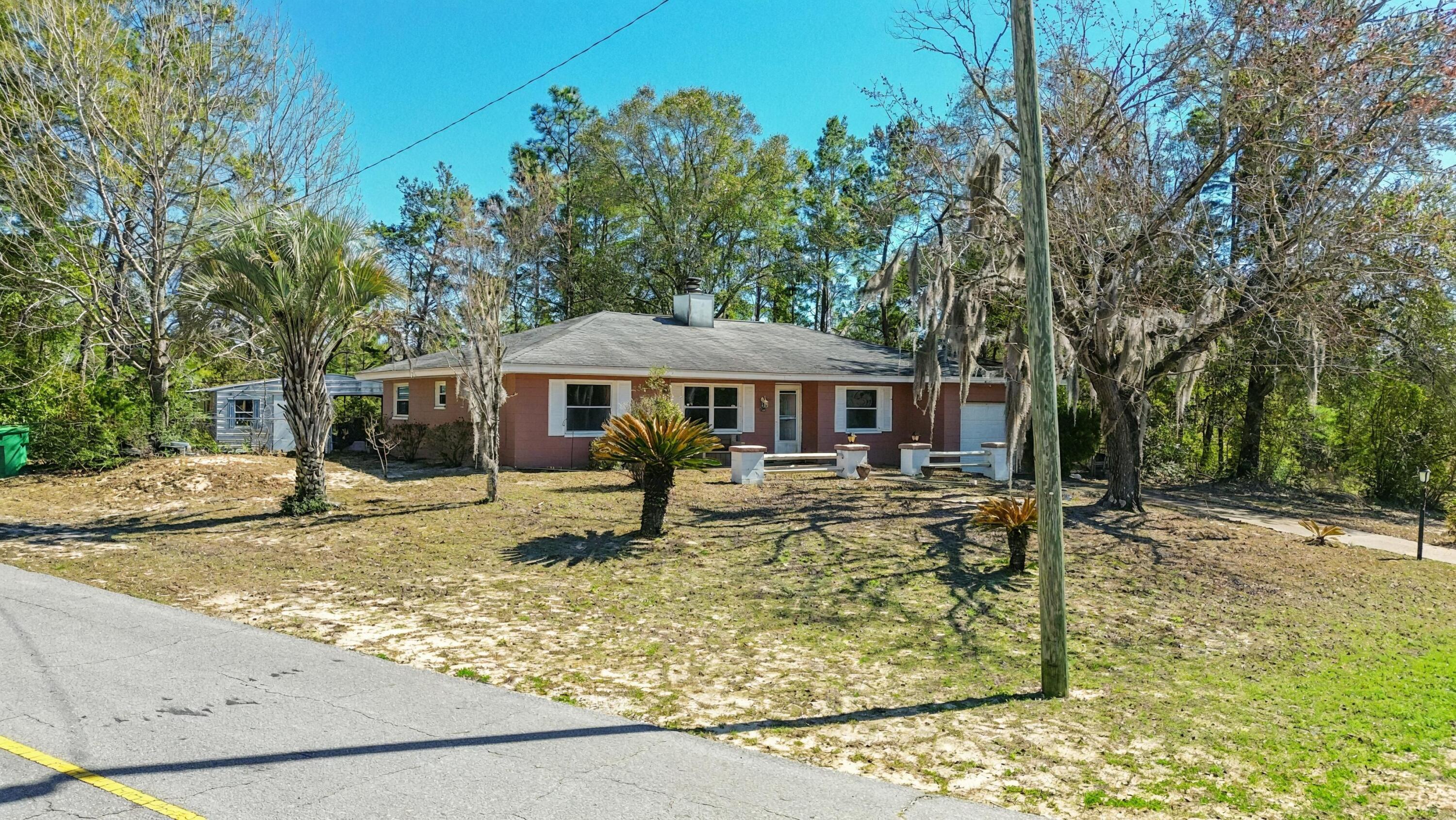 Peaceful Wooded Retreat with Workshop in Sunny Hills! Embrace the tranquility of Florida living in the established golf course community of Sunny Hills! Perched high on a private, wooded 1/3-acre corner lot, this 3-bedroom, 2-bathroom home offers 1,434 sq. ft. of comfortable living space surrounded by nature. Step inside to a highly functional, easy-to-maintain interior featuring durable Luxury Vinyl Plank and tile flooring throughout, absolutely zero carpet! The layout flows seamlessly out to a massive screened-in porch, creating the ultimate indoor-outdoor living experience. It is the perfect, bug-free spot to enjoy your morning coffee or evening meals while taking in the serene, private views of your fully fenced backyard. A Hobbyist & Storage Dream: In addition to the attached 1-car garage, the backyard features a fantastic detached workshop complete with an extended covered storage area. Whether you need a dedicated space for woodworking, storing outdoor equipment, or tackling weekend projects, this property has you covered. Big-Ticket Peace of Mind: Spend less time worrying about major maintenance and more time enjoying the Florida lifestyle. This home features key updates including: Roof Replaced (2019) Updated HVAC System and Updated Water Heater. The seller is offering a generous $5,000 Buyer Credit at closing for any desired upgrades/updates! With the major mechanicals already updated, buyers can use this allowance to bring their own vision to life by upgrading the kitchen and bathrooms to their exact taste, buying down their interest rate, or covering closing costs. Located in the desirable Sunny Hills community, residents enjoy access to an 18-hole golf course, excellent fishing at nearby Gap Lake, and a beautiful white-sand swimming beach at Boat Lake. Conveniently located just a short drive to the conveniences of Chipley and an easy commute to the world's most beautiful beaches! Don't miss the opportunity to customize this peaceful retreat. Schedule your showing today!