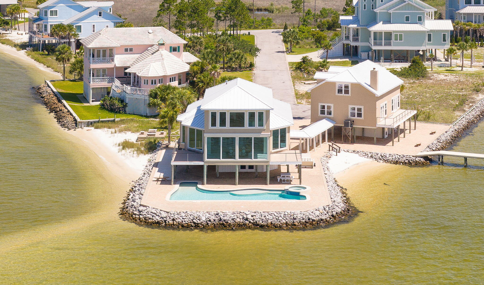 WRAP-AROUND WATERVIEWS!  PRIMARY HOME, GUEST HOUSE, POOL, BOAT DOCK & PRIVATE BEACH! Introducing 320 Sunny Drive, THE Crown Jewel of Emerald Coast Waterfront with over 180-degree views from the Santa Rosa Sound to the Gulf.  The 3B/2.5B main residence boasts views that will absolutely take your breath away!  The first floor open concept is an entertainer's dream, while the second floor is a relaxing primary retreat. Even the separate 3B/2.5B guest house features water views from almost every room.  The expansive waterfront pool patio is surprisingly secluded, with paved paths leading to the private beach, boat dock (2018), fire pit, shuffleboard and chess. Parking is abundant and Tesla ready. Inside Sandy Pointe, a gated community, 320 Sunny Drive is a MUST SEE!