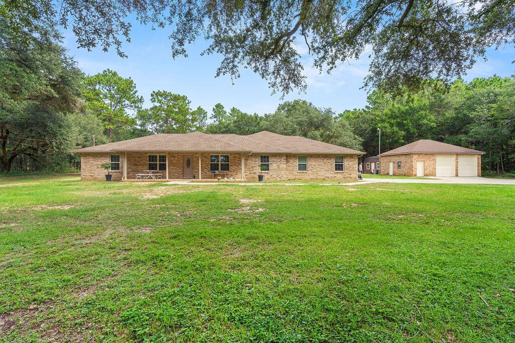 Situated on just over 3 acres in Milton, this 4 bedroom, 3.5 bathroom home offers plenty of space inside and out while providing a rural setting convenient to everyday amenities, area military installations, and less than an hour from the gorgeous waters of Pensacola Beach! TURN KEY with interior updates such as paint, flooring (NO carpet!), countertops, cabinets, fixtures, + more! The home features TWO primary suites, offering flexibility for multi generational living or guests. Galley style kitchen provides abundant cabinet and counter space, while the butlers pantry adds even more storage. A second living area offers versatile space for a media room, home office, playroom, or additional family room. Exterior features provide much opportunity for even the most discerning buyer- plenty of space AND privacy PLUS a massive detached workshop/two-bay garage. In addition, there is a climate controlled shed/workshop and a third storage building with a roll up single-car garage door. RV parking includes 30 amp service PLUS a dedicate carport. Important updates: roof 2020, HVAC (two units, 2020, 2023), windows 2017,  natural 24kW whole house generator, and seamless gutters.