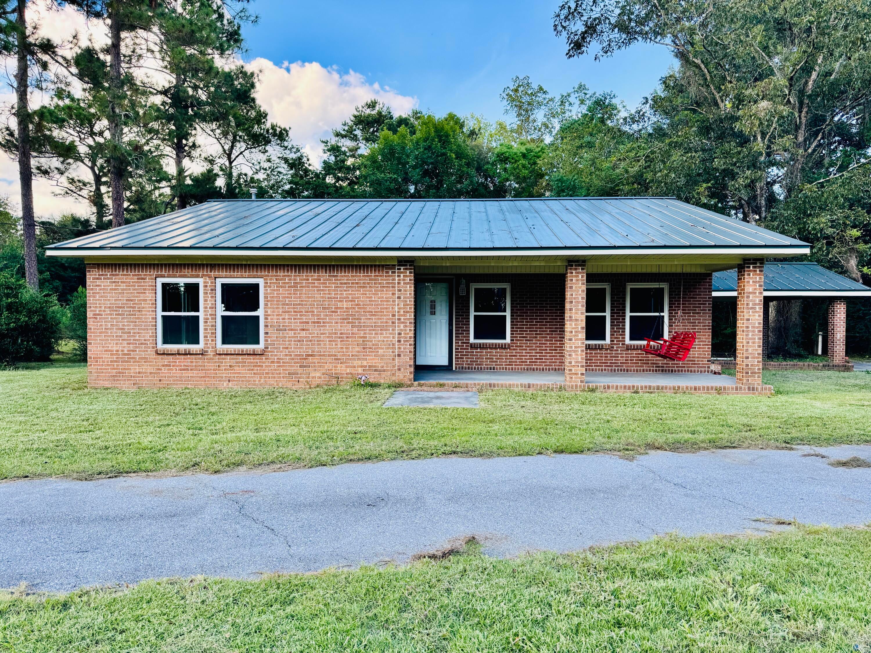 Nestled on a sprawling 9.4 acres, this solid brick 2-bedroom, 2-bathroom home offers a rare blend of country living and incredible potential. With an abundance of road frontage and two serene ponds on the property, this is a nature lover's paradise. Inside, the home is full of rustic charm, featuring beautiful exposed brick in both the kitchen and the main living room. The spacious back porch, previously screened in, is an ideal spot to relax. A large, versatile barn provides endless opportunities for storage, hobbies, or livestock. Adding to its appeal, the home boasts a durable tin roof. Please note, the HVAC system will require some work, and the property is being sold strictly ''AS-IS.'' This is a fantastic opportunity to own a substantial piece of land with fantastic bones at an attractive price. Don't miss your chance to make this unique retreat your own.