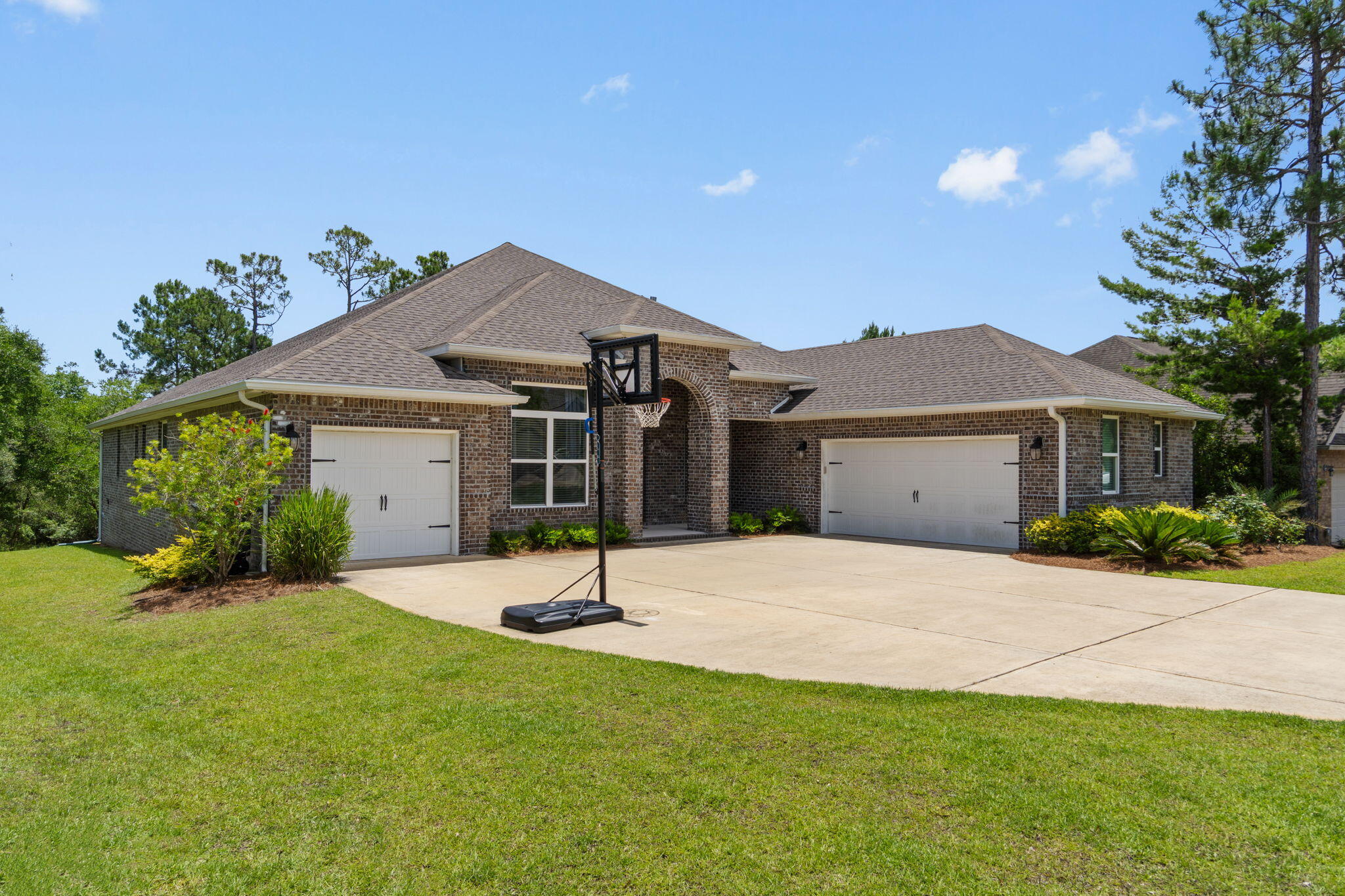 Located in the highly sought-after planned community of Hammock Bay, this exceptional 2021-built Monaco E floor plan offers the perfect combination of luxury, space, and functionality in a 2021 built home. Featuring 4 bedrooms, 3 bathrooms, a dedicated office, formal dining room, and a rare 3-car garage, this home provides two versatile flex spaces to fit your lifestyle - whether you're looking to have a home office, playroom, formal dining room, etc this home can fit your needs. Step inside to discover soaring 12-foot ceilings, elegant crown molding throughout, arched doorways, and beautiful EVP flooring that create a bright and inviting atmosphere. The spacious living room is highlighted by a stunning shiplap accent wall and seamlessly flows into the gourmet kitchen, complete with quartz countertops, white cabinetry, a large center island, stainless steel appliances, and a convenient butler's pantry and coffee bar area. The private owner's retreat is a true sanctuary featuring a tray ceiling, sitting area, and a luxurious en-suite bath with double quartz vanities, a soaking tub, and a tiled walk-in shower. Thoughtfully designed with both comfort and style in mind, this home offers plenty of room for everyday living and entertaining. Situated on an expansive 0.59-acre lot backing to trees, you'll enjoy exceptional privacy and plenty of room to create your dream outdoor oasis, including space for a future pool. The screened-in back patio is perfect for relaxing year-round, while the custom stone fire pit area creates the ideal setting for gathering with family and friends on Florida evenings. As a resident of Hammock Bay, you'll enjoy resort-style amenities including multiple pools, tennis, pickleball and basketball courts, a fitness center, dog park, walking trails, playgrounds, waterfront bay access at the Steamboat Landing clubhouse, and year-round community events. Conveniently located near the beaches of South Walton, Choctawhatchee Bay, shopping, dining, and top-rated schools, this home offers the best of coastal living in one of Freeport's most desirable communities. Don't miss your opportunity to own this beautifully appointed home with space, privacy, and incredible amenities both inside and out.