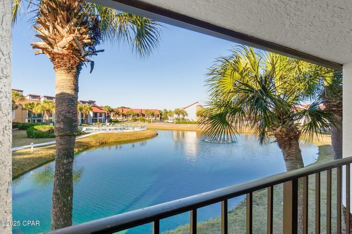 VA Approved AND nice price! Villa 1005 at Edgewater Beach Resort is offered turnkey and can be used as a short-term vacation rental. You have found a well-maintained second-home in a low-rise 2-story building. It is an oversized prime second-floor END UNIT; with a resort pool view over a pretty pond. Inside, you'll find stylish 18'' tile flooring throughout with cozy carpeting in the bedrooms. The condo boasts paneled doors, solid surface kitchen counters, custom cabinetry, a tiled shower in the master, an updated guest bathroom, and more. It's a relaxed coastal oasis with spacious rooms, an easy flow, and floor-to-ceiling windows. Step out onto your private balcony to relax and renew. There is a yard that is ideal for your pet. The full kitchen includes a breakfast bar, dining area, and full-size laundry. Just steps away, you'll find a private heated Villa pool, and the beachfront amenities are a short walk or tram cart ride away. Villa owners enjoy full access to Edgewater's exclusive Gulf-front amenities, including beach access, tropical pools, hot tubs, restaurant, bar, and market serving Starbucks coffee. There is a Kids Club featuring a splash pad, arcade, and special activities. The Sports Club in the center of the Villas features a fitness center and pro shop, with unlimited golf, tennis, pickleball, basketball, and shuffleboard. Security is top-notch with manned gates at all entrances. Parking is super convenient with building-side spots, including RV, boat, trailer, and electric charging stations. Plus, you're walking distance to shopping, dining, and entertainment right across the street. Exciting Pier Park and the dog beach are just a few minutes away. Want to know how affordable it can be? Ask for a Cost To Own Estimate and start making your beach dreams a reality.