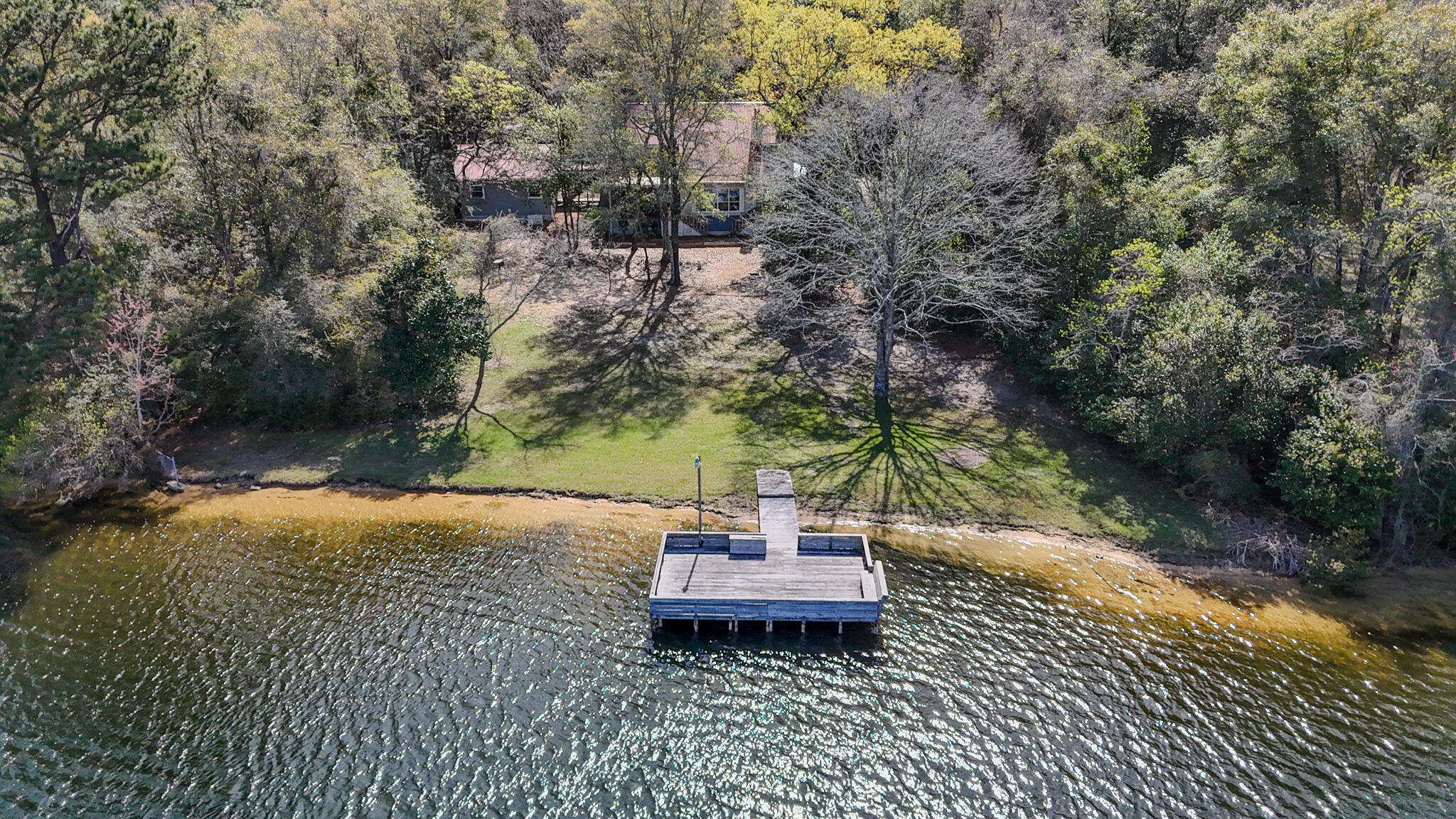 Nestled on 1.3 acres with almost 200 feet of  lake frontage, this impeccably maintained 4 BR 2.5 BA home on Spring Lake is not a listing you find everyday. Stepping into the home, you are greeted with incredible lake views from the open concept living area and kitchen, as well as exceptional views from the main floor master bedroom. The Master Bedroom features a large bath with walk in shower and separate jetted tub  Also located on the main floor is a walk in pantry/laundry room, a formal dining room, a half bath and a screened in sun room for enjoying gorgeous sunset views! 
Upstairs you will find 3 additional bedrooms and a full bath.  

SEE MORE This home has so many extra features such as a certified storm shelter in the master bedroom, a Generac whole home generator, an on demand tankless water heater, RV hookup, an oversized two car garage with attic connected to the home by a breezeway, a whole home security system and the neighborhood even has a FLOCK camera with 24/7 monitoring!
For reduced insurance and peace of mind, the metal roof is less than 3 years old. The septic system was replaced in 2025. 
Travel from the back deck down the very gently sloped yard to the showstopper of this property, gorgeous Spring Lake! Spring Lake Estates is a small community of homeowners who enjoy a quiet, peaceful way of life in the lakeside community built around a 150-acre private lake. Amenities include a large dock & boat launch area, pole barn & community gathering space, smaller common area dock for relaxation and two dedicated community access points.