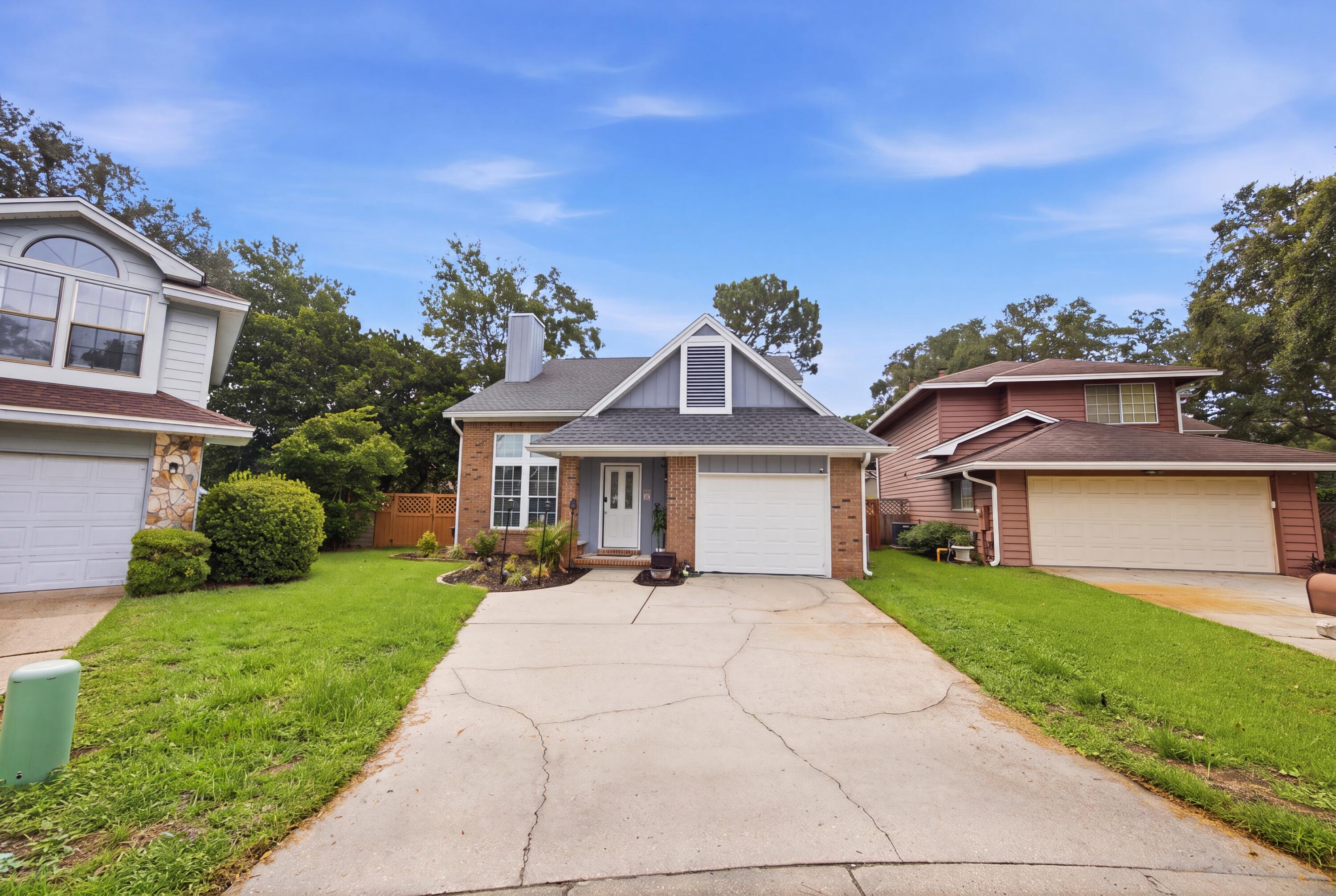 Updated two-story home in Crosswinds Landing. Featuring a classic brick accent exterior, attractive blue siding, and lush curb appeal, this residence welcomes you right from the covered front entry.
Inside, an impressive light-filled foyer features soaring vaulted ceilings and a striking grand staircase with painted risers and modern railings. The functional kitchen shines with rich two-tone dark and white cabinetry, a stone-pattern backsplash, stainless steel appliances, and open shelving. A convenient pass-through window looking into the living and dining space is perfect for entertaining.

A major highlight of this layout is the downstairs primary bedroom ensuite, offering total privacy and direct view of the backyard, with an updated bathroom featuring a modern lighted vanity mirror and custom tiled shower. Upstairs, spacious additional bedrooms feature vaulted architectural angles, laminate flooring, and easy access to a second updated bathroom complete with double vanity sinks and a custom tiled bath.

Step out back to your fully fenced, grassy backyard featuring a covered patio, ideal for pets, outdoor dining, or relaxation in your private outdoor space. Sitting on a generous lot, this property offers incredible style, flexible living spaces, and is in a desired neighborhood. Sitting just 6 miles from Eglin AFB, 8.4 miles from Hurlburt Field, and 12 miles from the Destin-Fort Walton Beach International Airport.