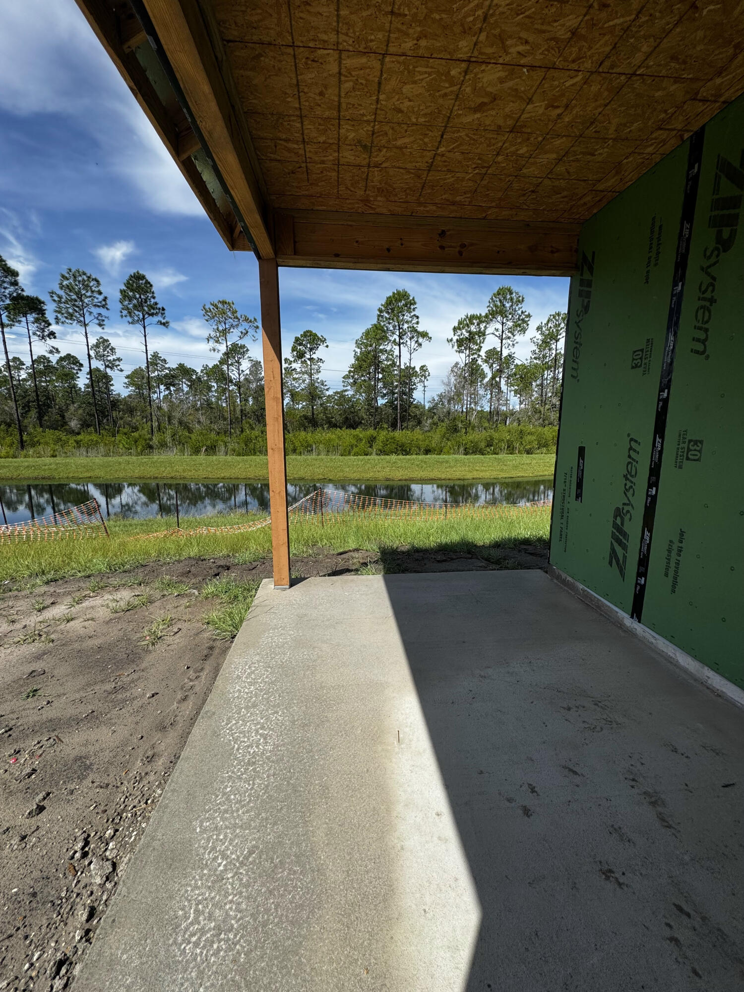 The Anfield plan offers 1,442 square feet with 2 bedrooms, 2 bathrooms, a powder room, and a 1.5-car garage in the Villas at Longleaf Park at Watersound Origins. Estimated completion is November/December 2026. 

Positioned on a homesite overlooking a retention pond with a wooded backdrop, the covered rear patio provides a peaceful setting to enjoy the view while maintaining the convenience of paired patio living. The floor plan features an open kitchen, dining, and family room with 10-foot ceilings, creating a spacious central gathering area. The kitchen includes a large island, walk-in pantry, gas cooktop, ceramic tile backsplash, and soft-close cabinetry with quartz countertops. 

The primary suite is tucked privately at the rear of the home and features a walk-in closet and an upgraded owner's bath with enhanced tile finishes. A secondary bedroom and full bath are positioned near the front of the home, while the added powder room offers convenience for guests. Luxury vinyl plank flooring extends throughout the home, complementing the clean, low-maintenance design.

Additional features include impact-rated windows, 8-foot interior doors, a tankless water heater, covered patio, Smart Home package, gas grill rough-in, and exterior lawn maintenance. Located just minutes from Watersound Town Center, Publix, restaurants, medical offices, and Highway 98, homeowners also enjoy access to the Origins Golf Course,  Village Commons, walking trails, and the amenities of the Watersound Origins community.