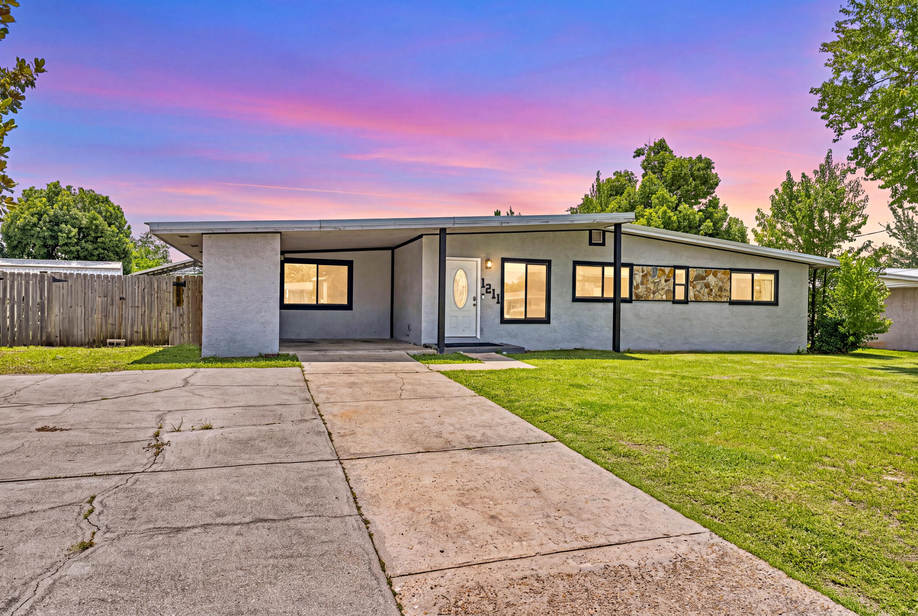 Spacious 4-bedroom, 3-bath home with modern updates, open living spaces, and a versatile backyard building -- approximately 1,800 sq ft. Welcome to this well-maintained single-story home offering comfortable living and excellent flexibility. The open floor plan features a large living room that flows into the dining area and kitchen, creating an inviting space for everyday living and entertaining. The updated kitchen has dark cabinetry, a stylish mosaic tile backsplash, stainless-steel appliances and a convenient center island with butcher-block top. LVP flooring runs through the main living areas for easy maintenance and a clean, modern look. A dedicated laundry room and tankless water heater add practical efficiency. Four bedrooms provide plenty of space for family or guests. The primary and secondary bedrooms offer good natural light & closets. Three full bathrooms feature updated vanities, showers and clean, functional finishes. Step outside to the big backyard -- fully fenced with a grassy expanse perfect for play, pets, or outdoor gatherings. A large yard building offers outstanding versatility: use it as a workshop, extra storage, or convert it into an in-law suite. A metal roof provides durable, low-maintenance protection, and the great location adds everyday convenience. This home combines practical updates, generous square footage, and outdoor potential in one appealing package. Ideal for buyers seeking space, functionality, and room to grow.