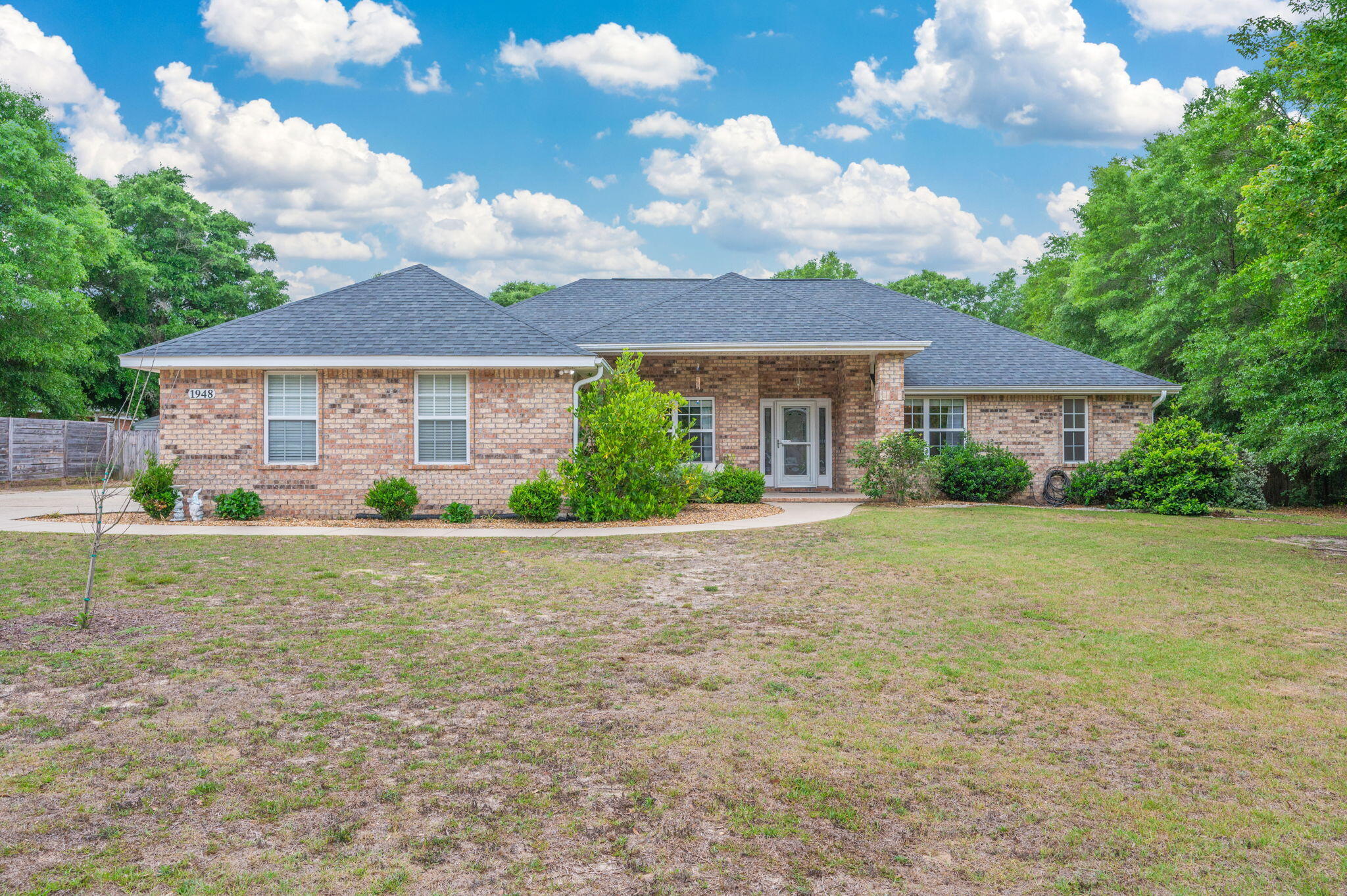 What!!!? 4BR Brick Home, 1 Acre in Baker
Contemporary 4 bed, 2 bath all-brick home with a split floor plan and tons of space inside & out! Bright, open kitchen with epoxy countertops and eat-in area. Flexible bonus room = dining, office, or playroom. Primary suite features tray ceiling, separate shower & whirlpool tub.
Enjoy a covered back porch, fenced yard, and TWO storage buildings (one with power!). Side-entry garage, solar panels for energy efficiency, and a 2021 roof = big perks, Don't miss this one!