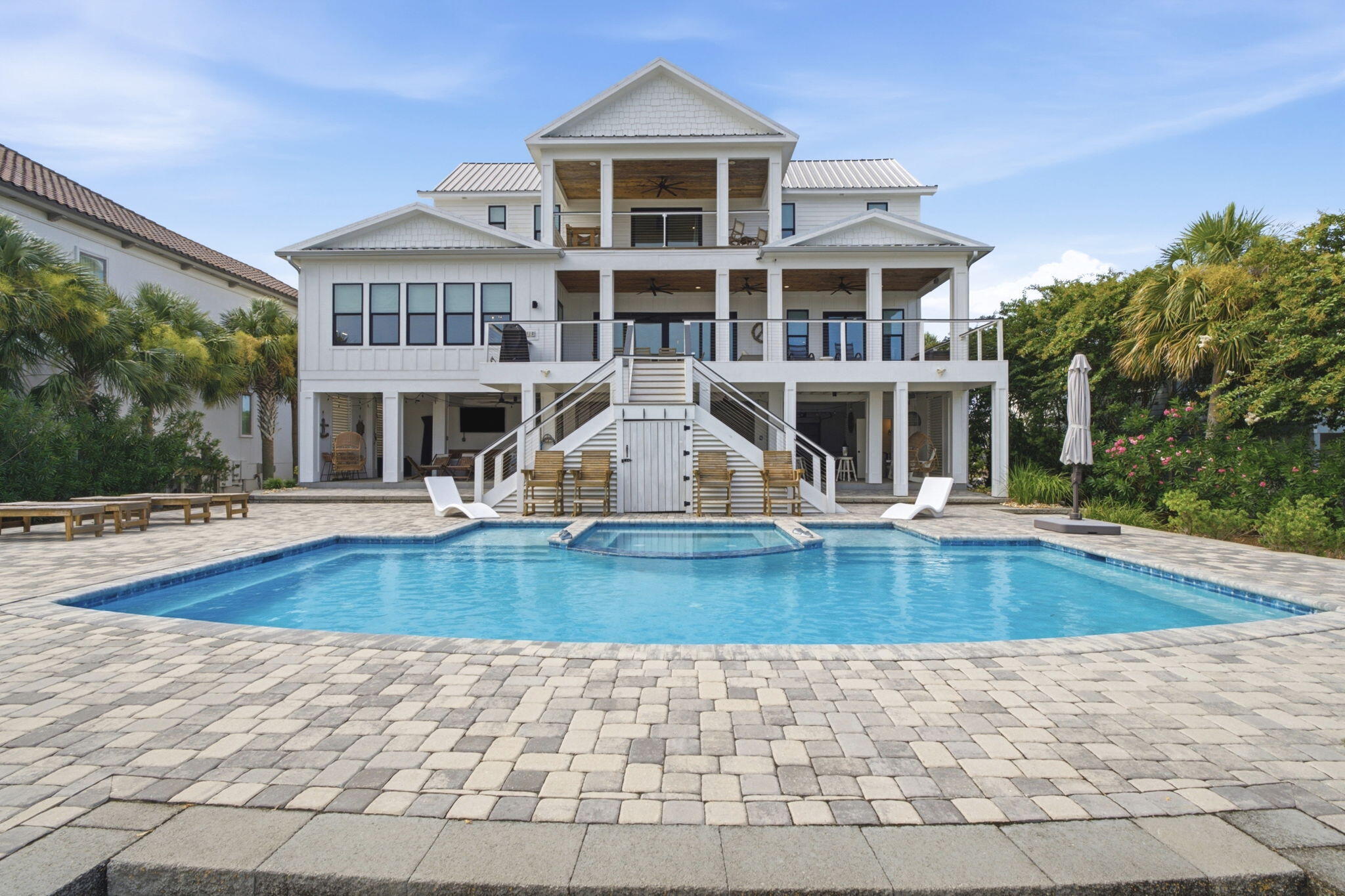 AN UNMATCHED ONO ISLAND LOCATION! Built in 2021, furnished, custom 5-bedroom, 5 full bath, 2 half bath luxury home spans nearly 4,000sqft on Bayou St. John in one of the island's most sought-after locations. Rarely does a property combine expansive waterfront views, premier boating amenities, newer construction, & the convenience of being less than a quarter mile from the Ono Island bridge for quick access on & off the island. The open floor plan showcases soaring ceilings, walls of windows, shiplap accents, designer lighting, plank tile flooring, custom tile selections throughout, & an elevator servicing every level. The chef's kitchen offers an oversized quartz island, premium stainless appliances, professional gas range, farmhouse sink, custom cabinetry, elegant tile backsplash, & an impressive butler's pantry. Bring your fresh catch straight from the dock to the kitchen with ease! Each bedroom offers a private bath, including a spacious primary suite with beautiful water views. A convenient half bath serves the main living level, while the oversized laundry room provides abundant cabinetry, workspace, utility sink, & exceptional storage. Completed in 2021, the outdoor amenities are every boater's dream. The heated & chilled saltwater gunite pool overlooks the bay, while the impressive 40' x 40' covered boathouse features two slips, a 20,000 lb interior lift, a 44,000 lb exterior lift, expansive dock space, swings on the dock overlooking the water, & a downstairs half bath & fishing gear storage & outdoor shower. The homesite was thoughtfully elevated during construction, enhancing both the setting & functionality of this remarkable waterfront property. Located on open Bayou St. John, you'll enjoy quick access to the Gulf, Intracoastal Waterway & Robinson Island. This combination of open water, luxury finishes, exceptional boating amenities, & one of Ono Island's most convenient locations rarely becomes available. Call today for your tour!