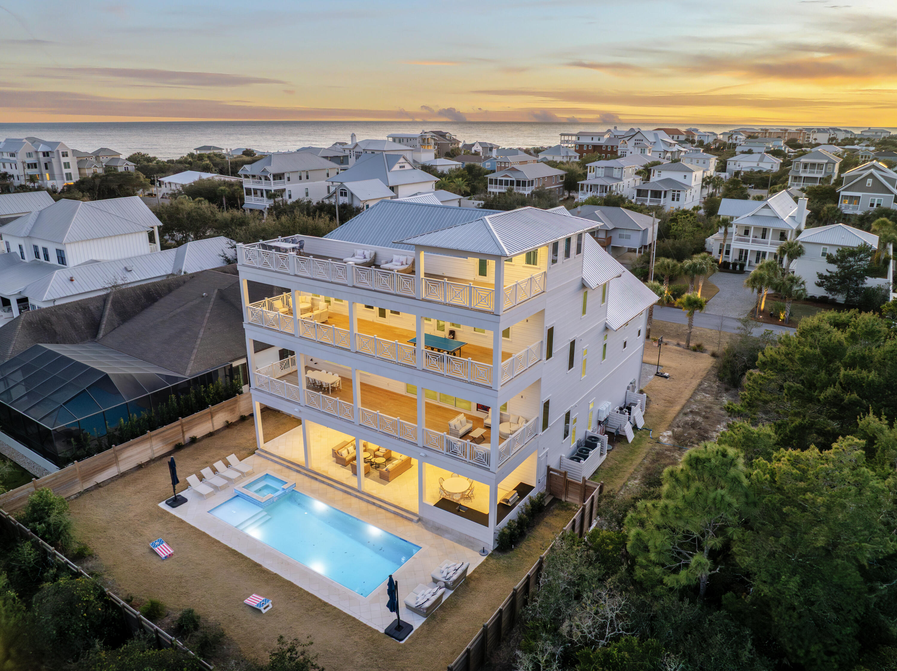 Welcome to 100 Brenda Lane, a contemporary coastal retreat in Inlet Beach offering private deeded beach access and sweeping Gulf views from sunrise to sunset. Designed to maximize both lifestyle and investment performance, the property generated $247,968 in rental revenue in 2025, underscoring its appeal as a premier luxury retreat along 30A. Spanning four thoughtfully designed levels, the residence features eight bedrooms and seven full bathrooms, along with a powder bath, creating generous accommodations for large gatherings while maintaining a sense of privacy and comfort throughout. A serene courtyard entry sets the tone, leading into interiors defined by clean architectural lines, soaring ceilings, and expansive walls of glass that frame the surrounding coastal landscape.
The main living level is anchored by a spacious great room and adjacent dining area, where full-view windows capture dramatic Gulf vistas and flood the space with natural light. The gourmet kitchen is designed with entertaining in mind, featuring a large center island, breakfast bar, walk-in pantry, and abundant custom cabinetry, all beneath a distinctive tray ceiling that adds architectural depth.
Outdoor living is seamlessly integrated into the home's design. A large game room opens through a wall of glass to an expansive paver deck with a private pool, raised spa, and covered lanai, creating a true resort-style setting for relaxation and entertaining. Multiple balconies extend the living space outdoors, including an impressive 57-foot balcony adjoining the upper-level suite.
The fourth-level rooftop terrace serves as the home's defining feature, offering uninterrupted Gulf views and an elevated vantage point for sunset gatherings, morning coffee, or quiet reflection above the coastline. Additional features include a private elevator servicing all levels and a two-car garage with additional storage.
Positioned along one of Inlet Beach's most sought-after stretches, 100 Brenda Lane offers a rare combination of architectural presence, private beach access, exceptional outdoor living, and strong rental performance, making it equally suited as a primary residence, second home, or investment property along 30A.