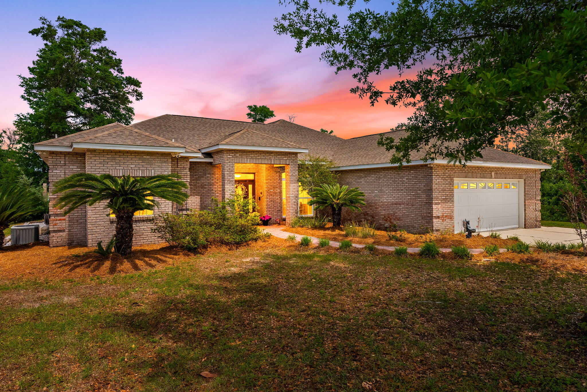 This exceptional home sits on 2.66 acres of direct Deerpoint Lake frontage in Bay County, Florida. Updated in 2017 and in excellent condition, it offers a rare combination of modern finishes, serious outdoor entertaining space, a detached garage, and a private boat dock.
The paved circle driveway with tall covered parking accommodates a boat, RV, or extra vehicles with ease. Brick construction and vinyl trim keep maintenance minimal -- a detail you'll appreciate before you even step inside. Inside, high ceilings and quality ceramic plank flooring set the tone throughout. Click ''more'' A formal dining room and ornate dry bar anchor the open floor plan, which flows naturally into a family room and adjacent sitting area centered around a large wood-burning fireplace -- both overlooking the incredible outdoor entertainment area beyond.
The peninsula kitchen is clean and modern: granite countertops, stainless appliances, and a Jenn-Air cooktop with built-in oven and convection microwave. The primary suite was fully enhanced in 2017 with an additional dedicated A/C unit, dual vanities, a tile rain shower, an alcove soaking tub, and a private toilet and bidet. The 2017 renovation also created a second primary bedroom -- a generous 12x22 with twin closets and its own bathroom. A Maytag washer and dryer convey with the home. The finished, oversized attached double garage connects directly to the kitchen for everyday convenience.
Outside, the east side of the property remains wooded for privacy. A 24x30 detached garage with high ceilings, LED lighting, and ceiling fans has been built out as a serious workshop -- wired with multiple 220V circuits for an RV connection, compressor, or welder. Paver parking extends along two sides. Behind the home, a 45x52 paver entertainment area features a built-in brick and stainless grill and a large stone fire pit. An electrical stub-out and outdoor shower are already in place for a future pool.
Down at the water, a private dock and covered 16x20 boathouse await. The property runs on a 4-inch well with a dedicated well house and filtration system serving the home and two irrigation zones. Septic and drain field eliminate city water and sewer costs entirely. No HOA. Flood Zone X -- no flood insurance required.