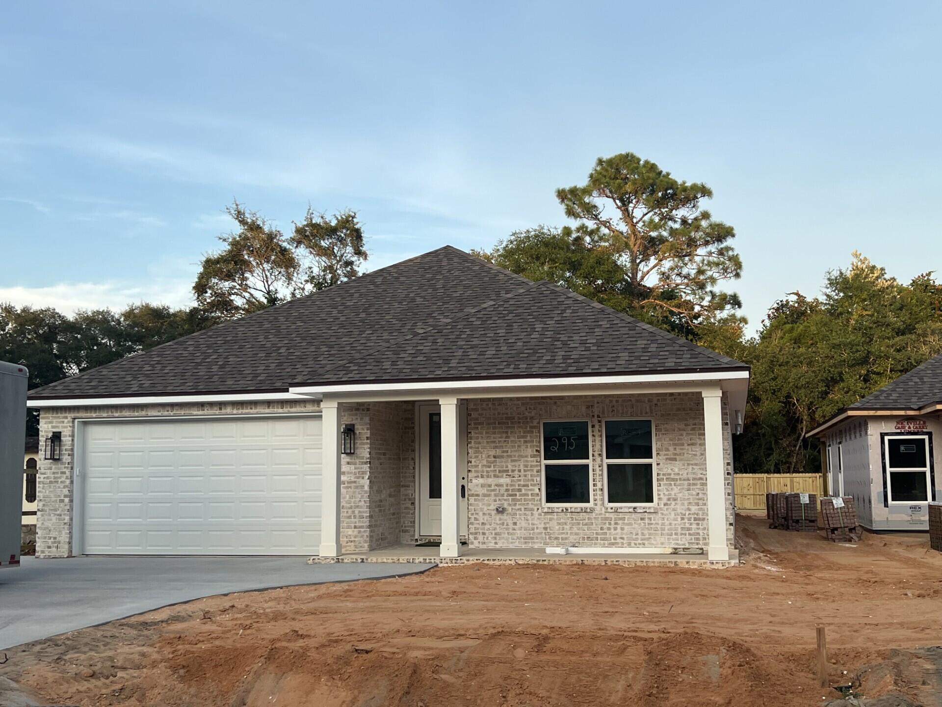 Stunning craftsmanship in this new construction all-brick 3-bedroom, 2-bath home sitting on a corner lot. This modern home features 1,905 sq.ft. with high-end custom finishes, and exceptional detail throughout the home.  Come get settled into a neighborhood less than 2 miles East of Bluewater Bay and the Mid-Bay Bridge surrounded by new construction! This home blends timeless quality with today's most desired features, creating a home that is as functional as it is beautiful. Entering the home, you have an oversized foyer that immediately sets the tone for the custom finishes found throughout. Premium LVP flooring throughout the entire home, paired with crown molding and reverse trey ceiling with lighting, providing a seamless aesthetic.  Enter into the spacious living room with an open concept that provides an abundance of natural light with high impact windows, neutral finishes and modern lighting. Additional features include a floor outlet in the family room, perfect for floor plugs, lamps or phone charges without obstructing walkways. The kitchen is a Show Stopper, designed with both style and functionality. Featuring white shaker cabinetry with soft close doors, a farm sink, white ceramic back-splash, quartz countertops, stainless steel Whirlpool appliance package and a large walk-in pantry. The oversized 8ft island and the 6ft coffee bar add the perfect finishes! As you enter the spacious primary suite, you're greeted with natural