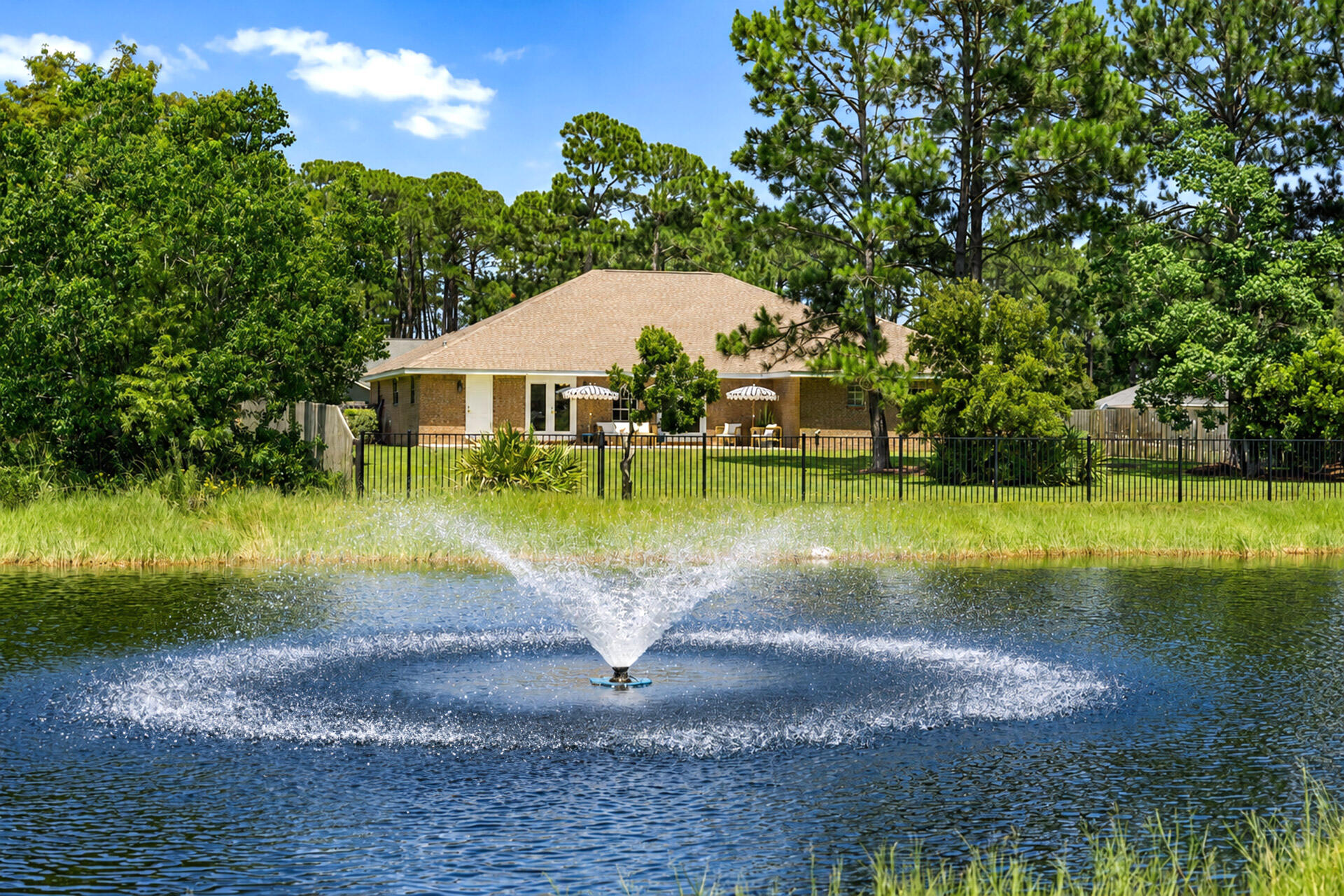 The park is your backyard at 565 East Shipwreck Road, a beautifully renovated waterfront home in Driftwood Estates offering 2,992 square feet, 4 bedrooms, 3 bathrooms, a dedicated office, and a 2-car garage on a spacious 0.573-acre lot in Santa Rosa Beach. Set along a peaceful pond with a fountain water feature directly behind the home, this property offers a rare setting with no rear neighbors and open views across the water toward Driftwood Estates Park. From the backyard, the lifestyle is hard to beat. Kids can grow up with the park just beyond the pond, where a track, basketball courts, soccer fields, tennis courts, pickleball courts, handball, playgrounds, picnic areas, pavilions, restrooms, and open green space create an incredible extension of home. Whether it is morning coffee by the water, afternoons at the playground, evening walks, or weekend games at the park, this setting delivers the kind of everyday convenience and outdoor lifestyle that makes Driftwood Estates so special. Inside, the home has been fully renovated and professionally designed with a warm, elevated coastal feel. The open living area features wood flooring, vaulted ceilings, designer lighting, and a fireplace, creating a bright and inviting main gathering space. The renovated kitchen includes quartz countertops, an island with eat-in bar seating, subway tile backsplash, floating wood shelving, gold hardware, and thoughtful accent details that complement the home's updated design. Doors from the main living area lead to the open-air patio and fully fenced backyard overlooking the pond, fountain, and park beyond.

The spacious primary suite features tray ceilings, generous proportions, and a beautifully updated bathroom with double vanities, a soaking tub, glass-enclosed walk-in shower, and walk-in closets. A dedicated office just off the living area provides a great space for working from home, studying, or creating a flexible second living area.

Additional highlights include a new roof in 2022, a brick exterior with dark shutters, ample parking, partially furnished design elements, and a large fenced backyard with room to enjoy outdoor living. Driftwood Estates is centrally located off Mack Bayou Road, convenient to Sacred Heart Hospital, Grand Boulevard, Sandestin, Miramar Beach, Destin, 30A, shopping, dining, schools, and the beaches of South Walton.

With its fully renovated interior, oversized lot, pond-front setting, dedicated office, and unmatched backyard views toward Driftwood Estates Park, this home offers a rare opportunity to enjoy space, style, and everyday recreation in the heart of Santa Rosa Beach.
